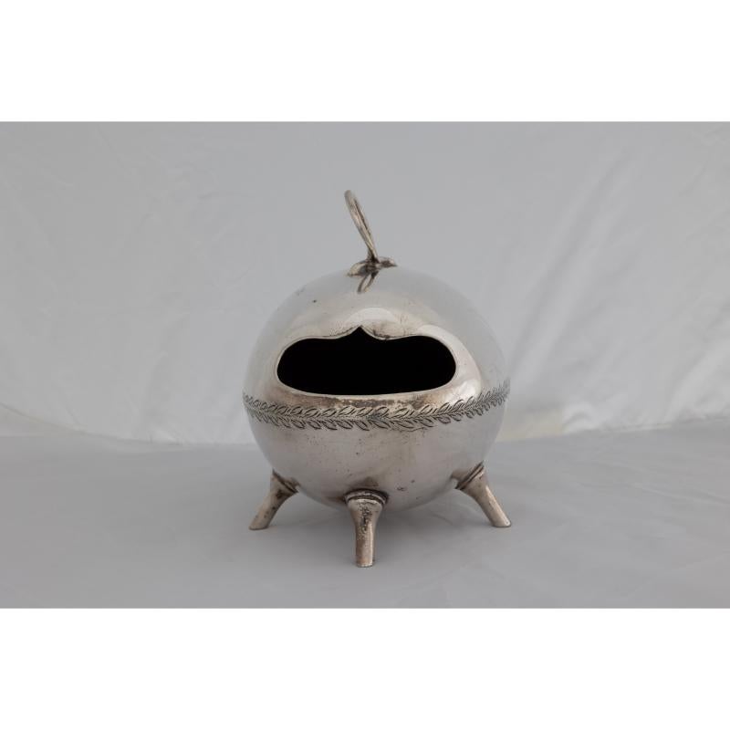 Walker Hall Sheffield after a design by Dr C Dresser. An Aesthetic Movement silver-plated ostrich egg shape spoon warmer with a circular handle, a mouth-shaped opening, and subtle hand chased leaf decoration around the middle, stood on three Dresser
