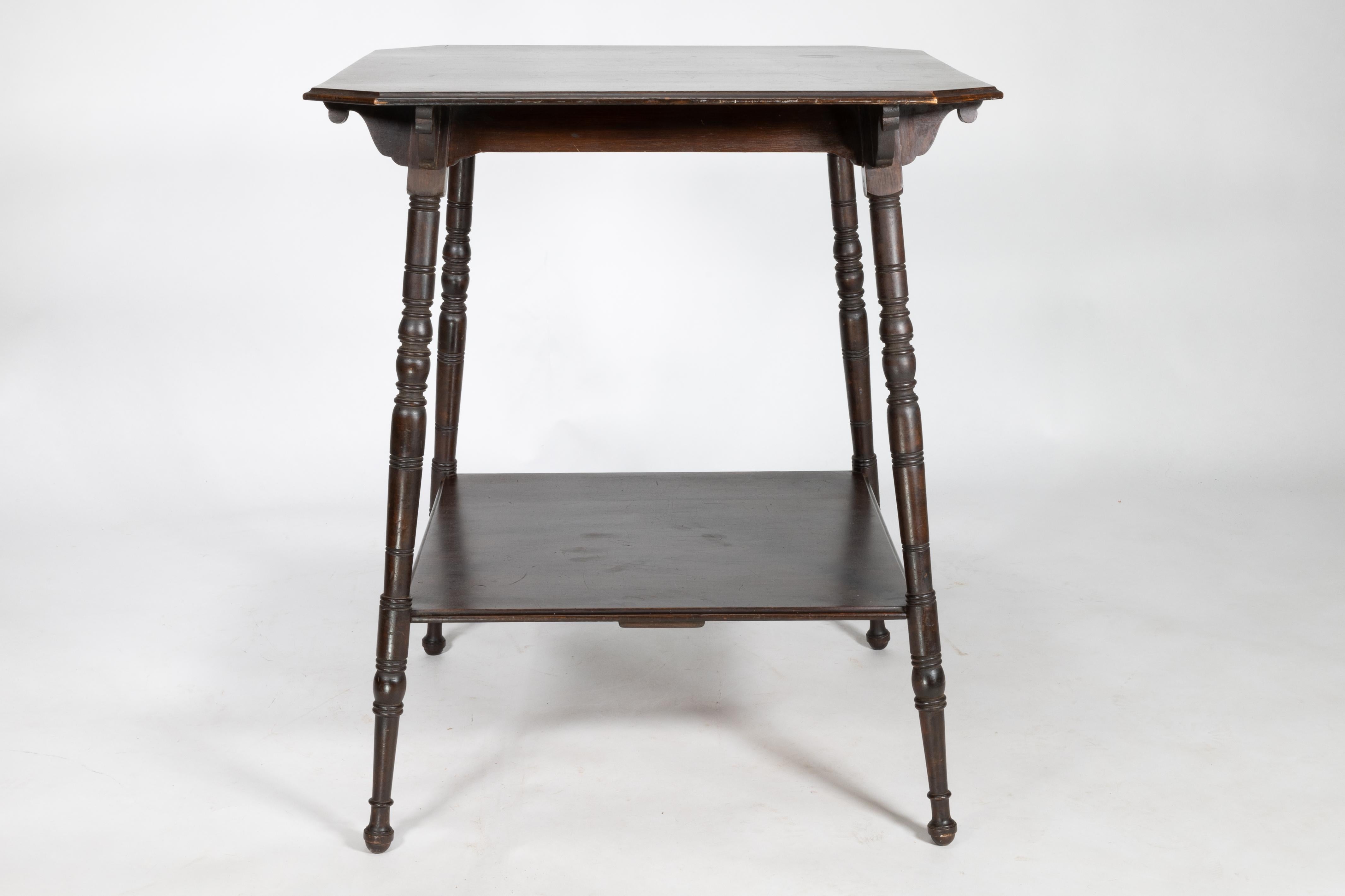 An Aesthetic Movement walnut two-tier side table with canted corners on fine ring turned legs
