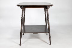 An Aesthetic Movement walnut two-tier side table with canted corners