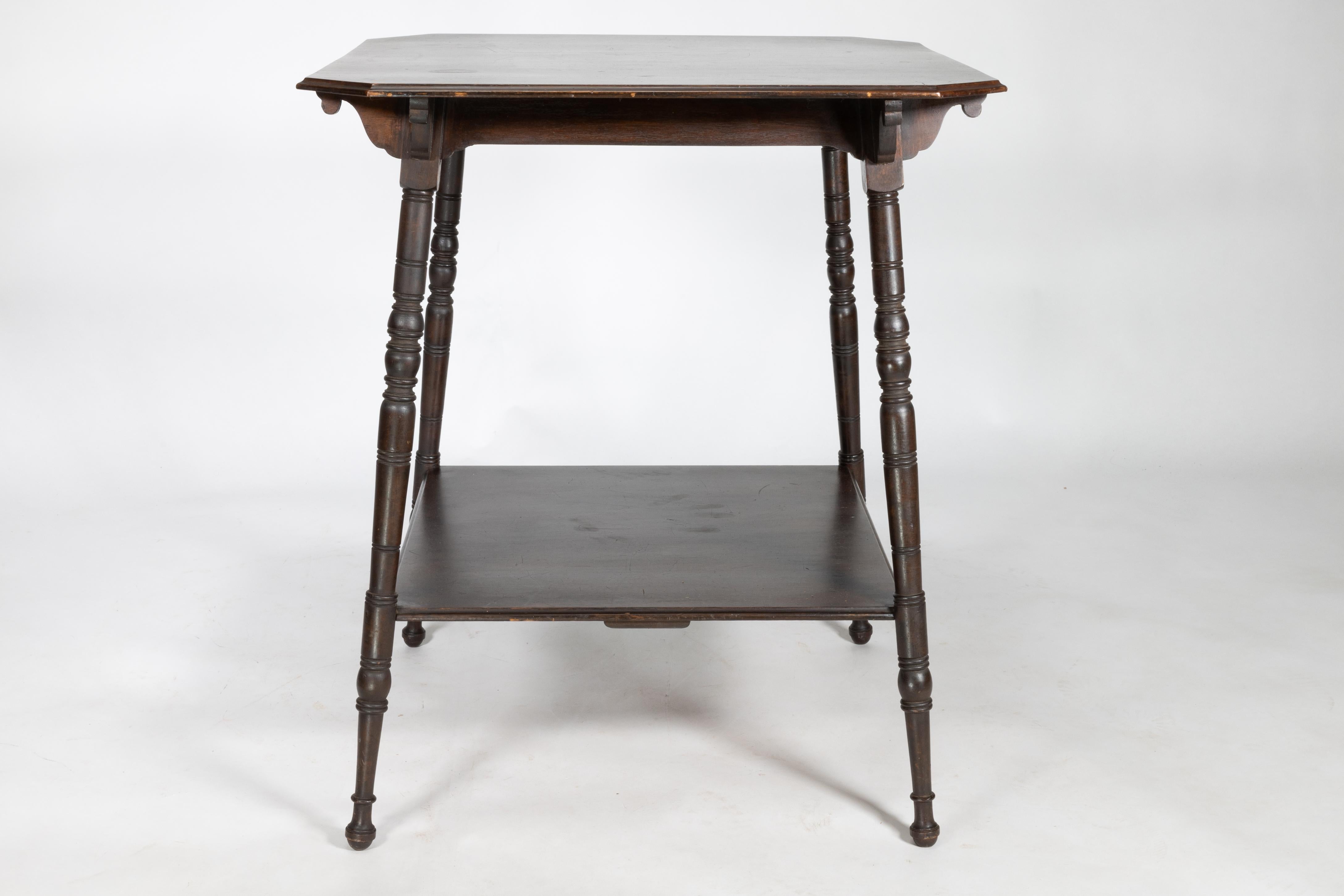 Late 19th Century An Aesthetic Movement walnut two-tier side table with canted corners For Sale