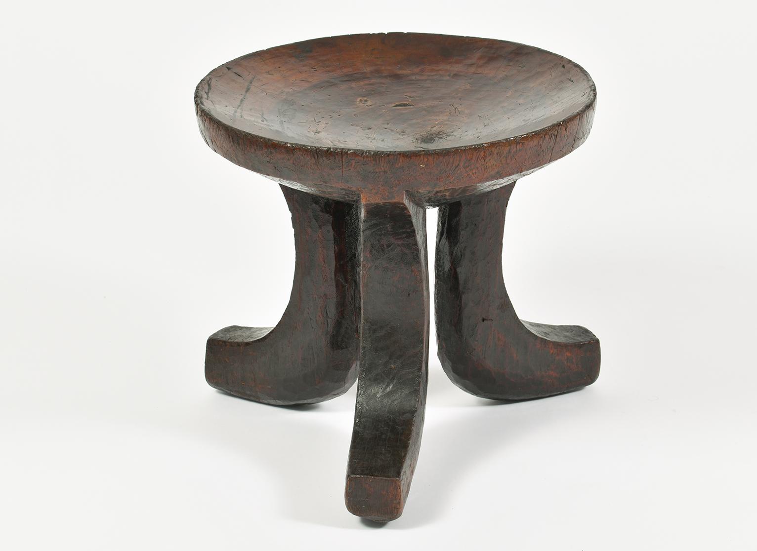 A tribal carved wood tripod stool
Africa, probably Ethiopia, mid-20th century.