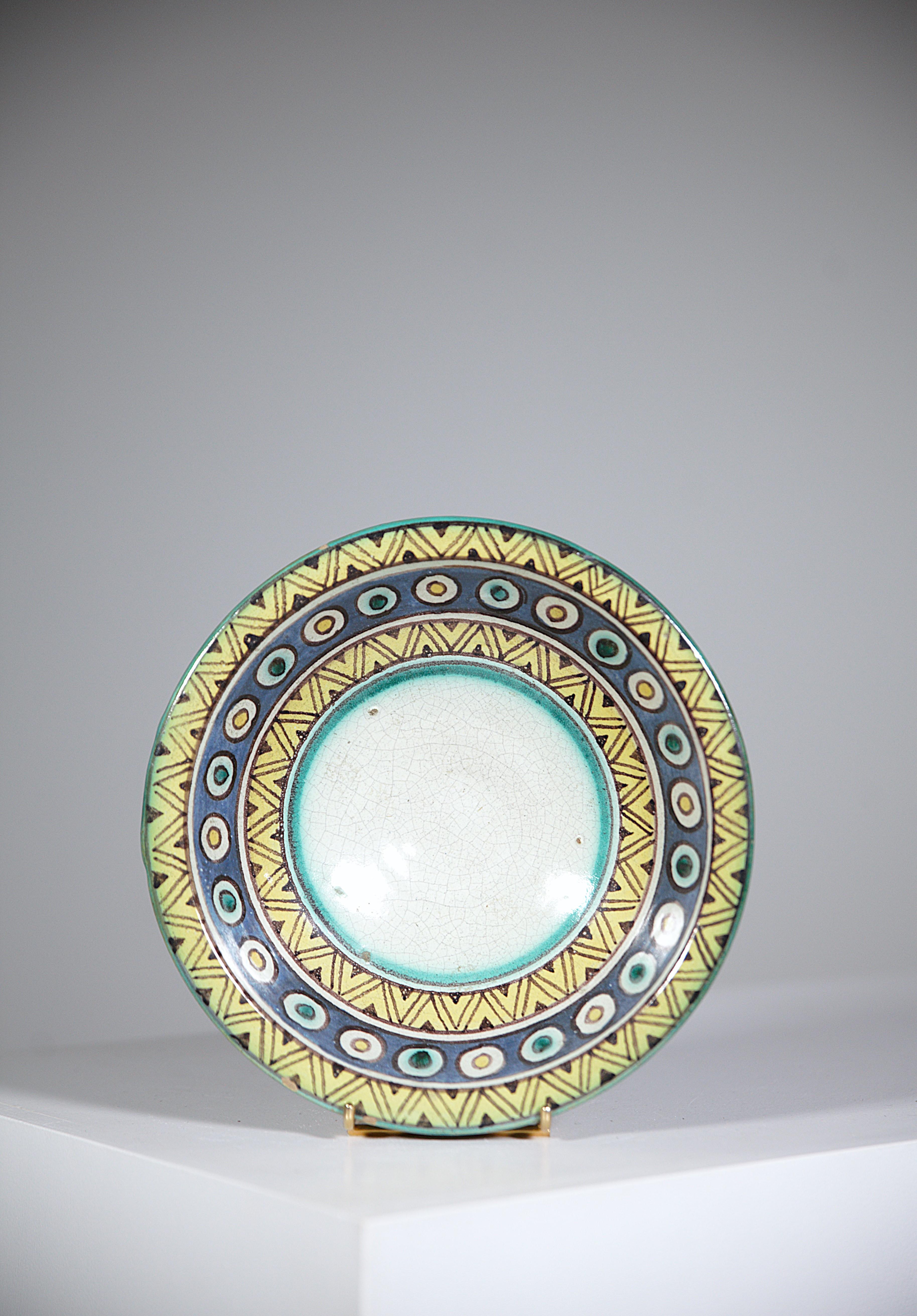 An Africanist Ceramic Bowl by Pierre De Verclos Nabeul Tunisia 1930's.

Pretty bright colors with geometric patterns.

Very beautiful white crackle in the center of the bowl.

Signed on the back.

Report : Light chips on the edge ( please consult