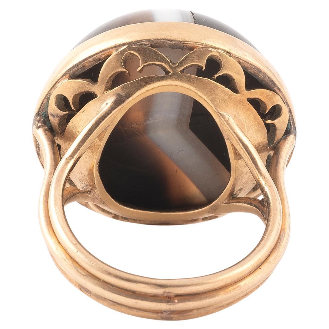 Ring with a cabochon agate. Basket with vegetal decoration. Frame adorned with three bodies in 18K yellow gold. Size: 6. Gross weight: 11.42 gr.