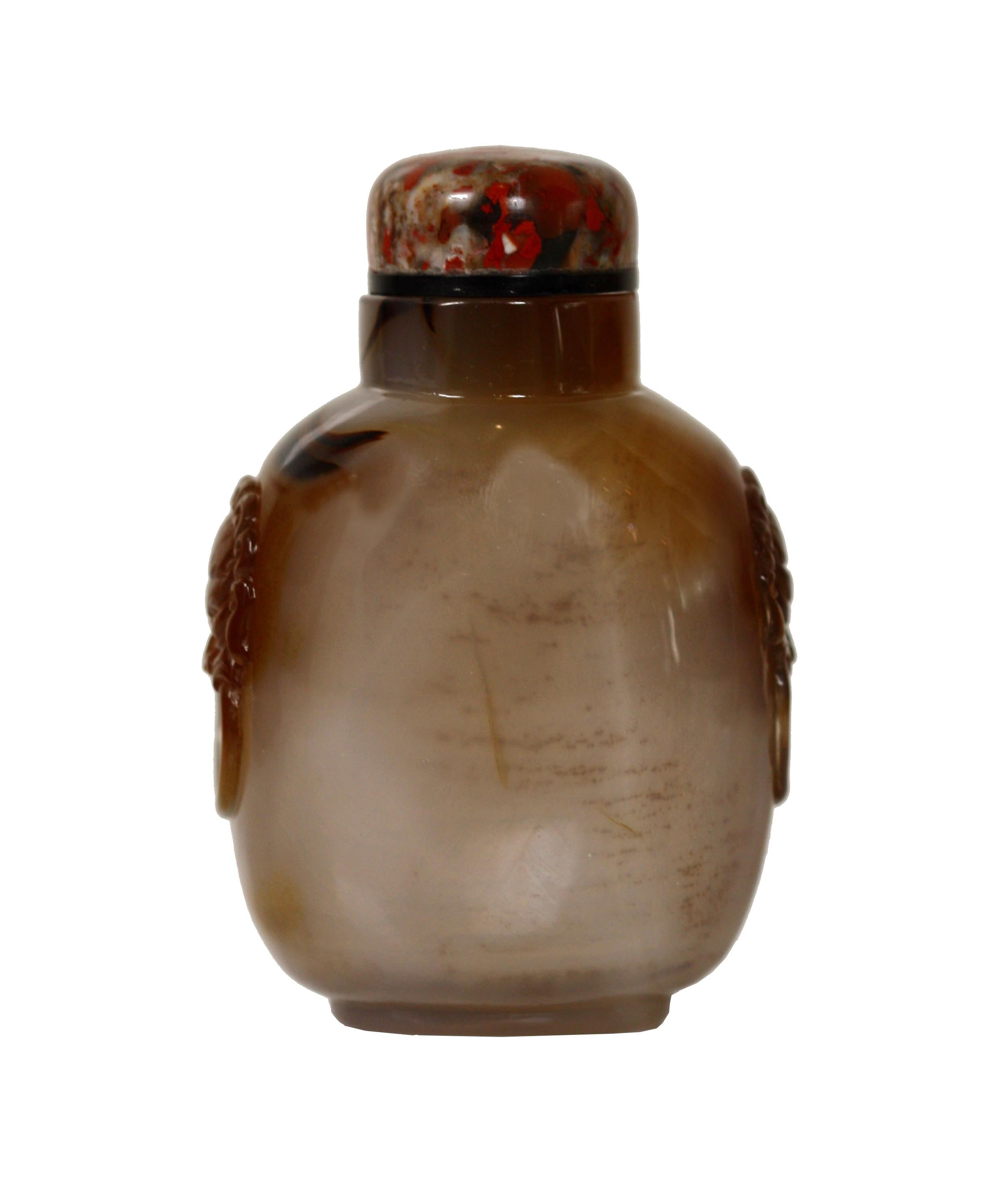 An Agate snuff bottle
Chinese, Qing Dynasty 19th century, of ovoid shape with rounded shoulders carved with lion-mask ring handles on the shoulders, has stopper
Measures: Height 3 in. (7.62 cm.)(including stopper).