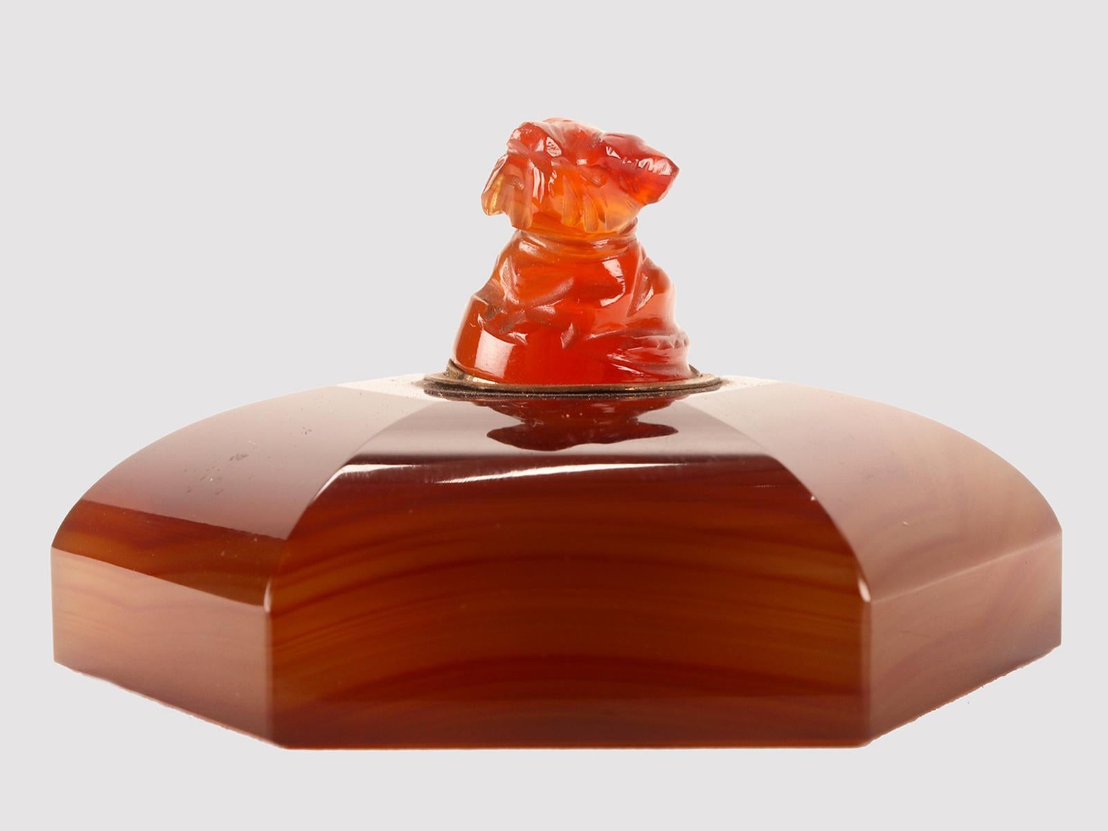 An agate table switch featuring a small terrier dog. The switch is carved and sculpted entirely in agate and carnelian. The body of the switch has a hexagonal base, the profile rises briefly to then curve towards the center and converge towards the