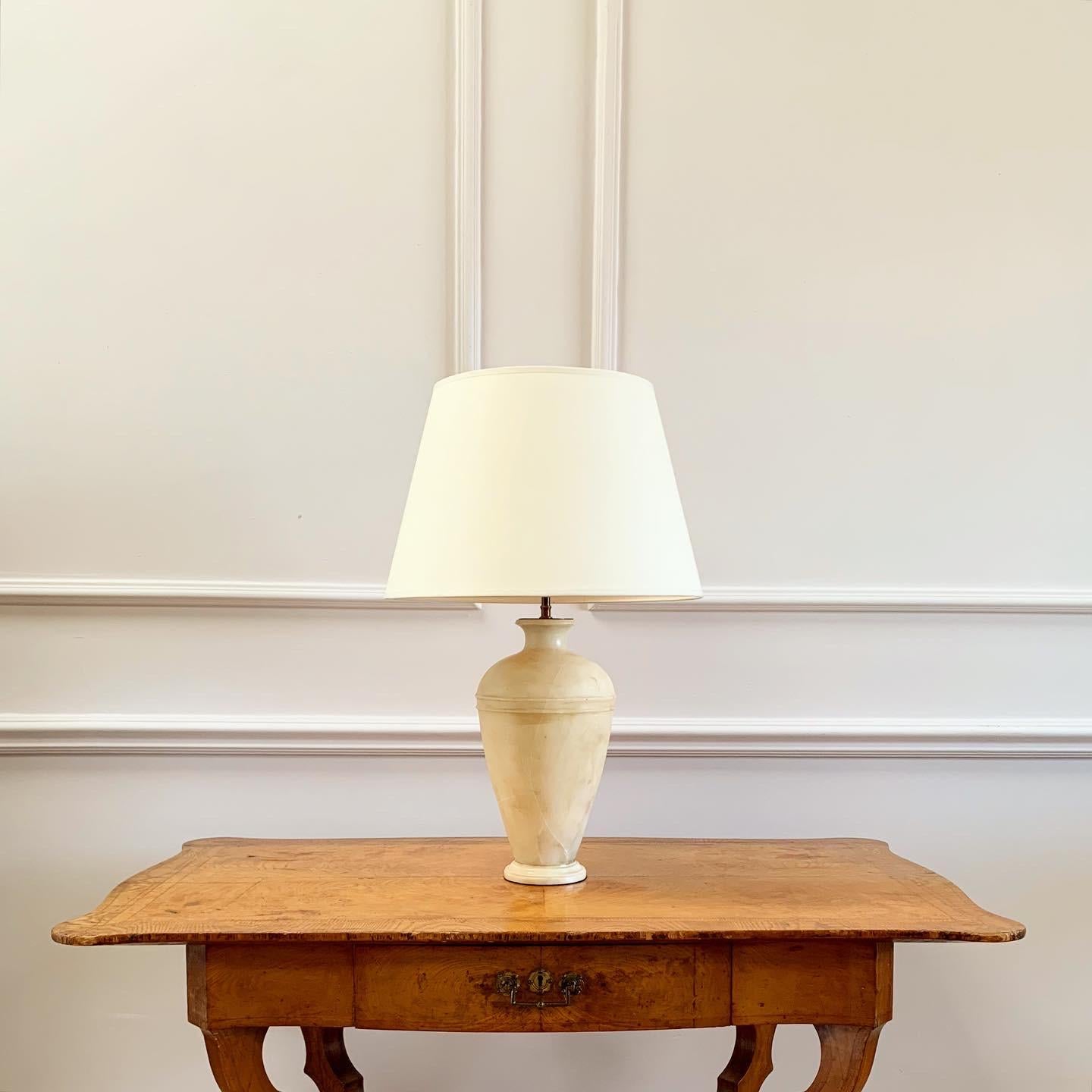 A classically shaped alabaster urn with tapered neck and turned ring decoration to shoulder, now mounted as a lamp.