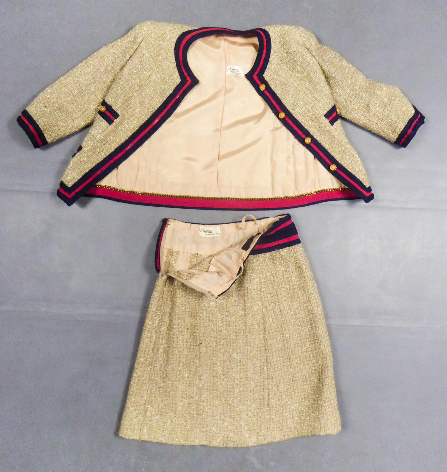 Spring Summer 1961

France

Haute Couture skirt suit by Chanel, 1961 Collection (attributed to). Skirt and jacket in black and cream checked twine wool tweed, outlined with fuchsia grosgrain and navy wool braids. Hollow openwork gilt metal buttons