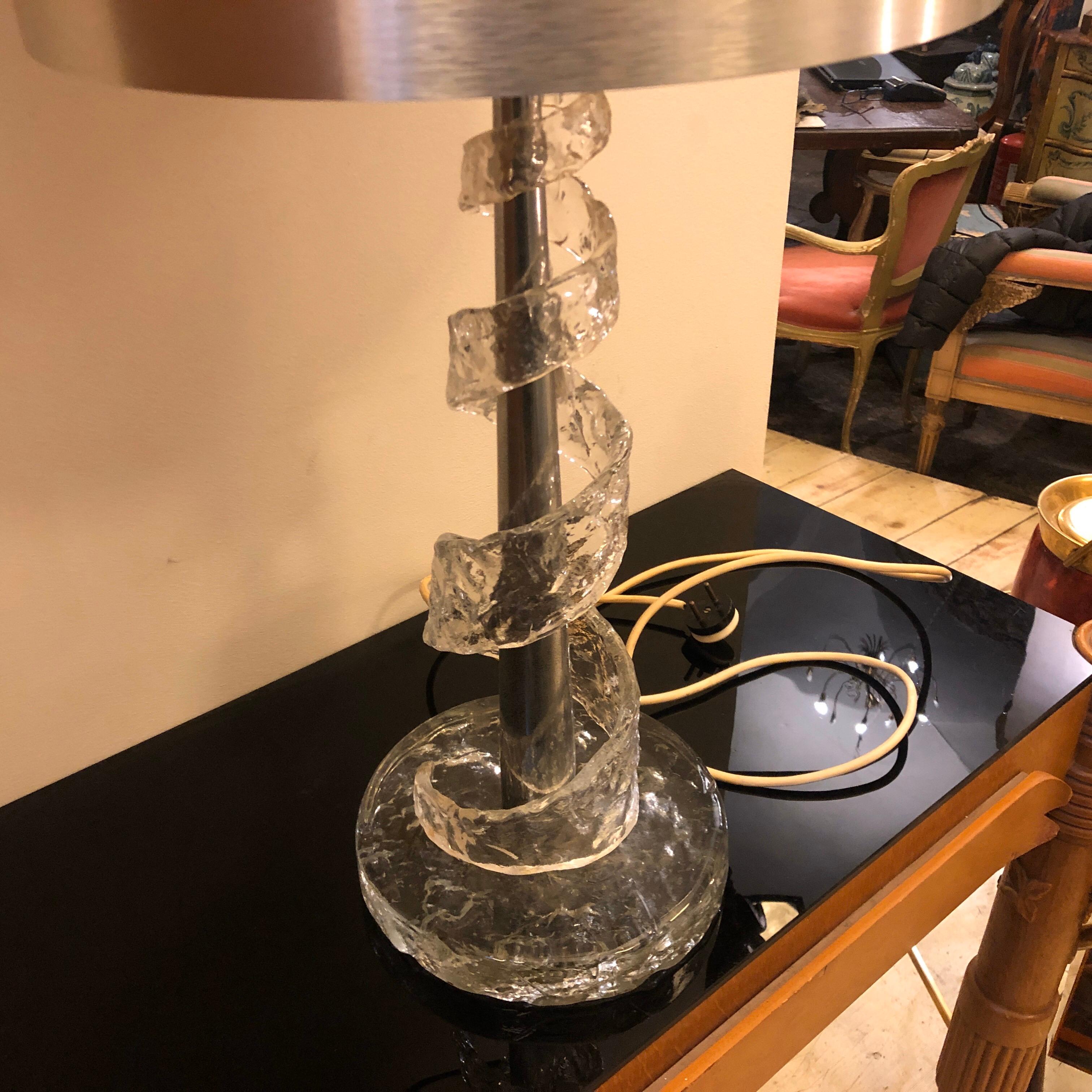 It's a particular Murano glass table lamp with original lampshade, it's made in two pieces, one is made of metal and glass, the spiral is made of transparent Murano glass. The table lamp has been designed by Angelo Brotto and manufactured by