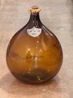 An Amber Glass Demijohn, Labeled Eau De Vie 1881