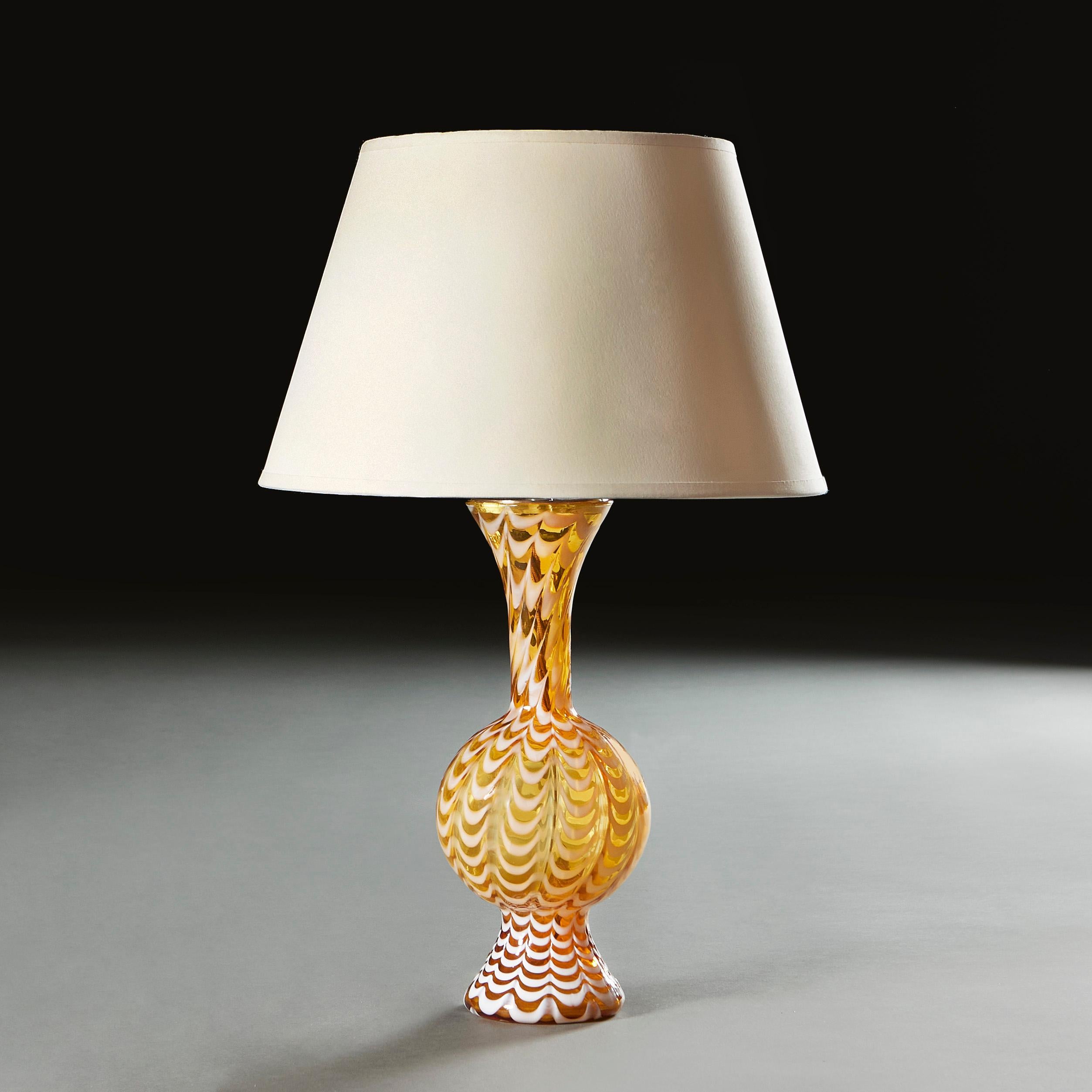 Italy, circa 1940

A midcentury Murano glass lamp, the amber glass with white feathered glaze with bulbous body and a flared neck. 

Height of vase 33.00cm 
Height with shade 56.00cm
Diameter of base 10.00cm

Please note: This is currently