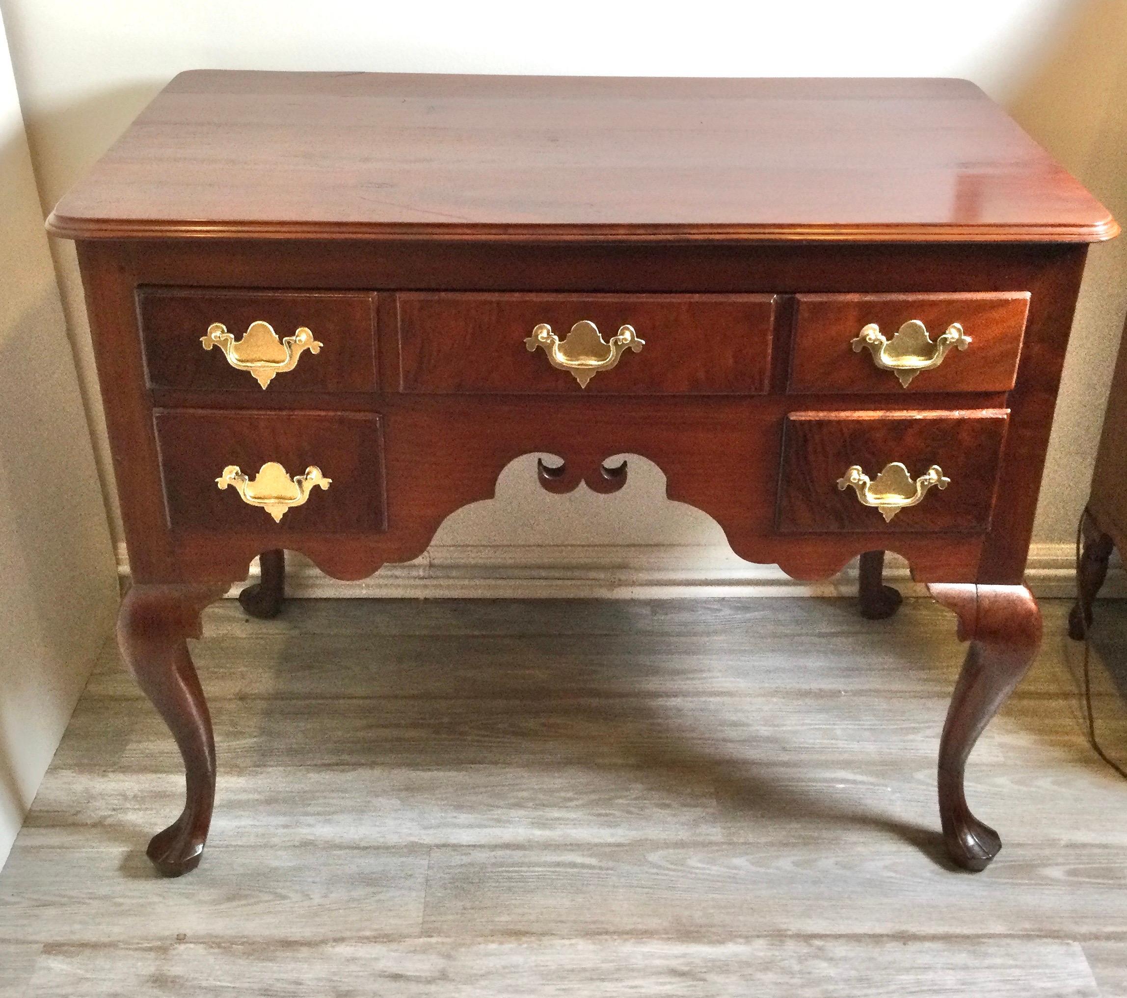 A classic American Queen Anne walnut lowboy with brass hardware. The shapely apron with three upper drawers with two smaller drawers below. The graceful legs with trifoot and stocking feet.
