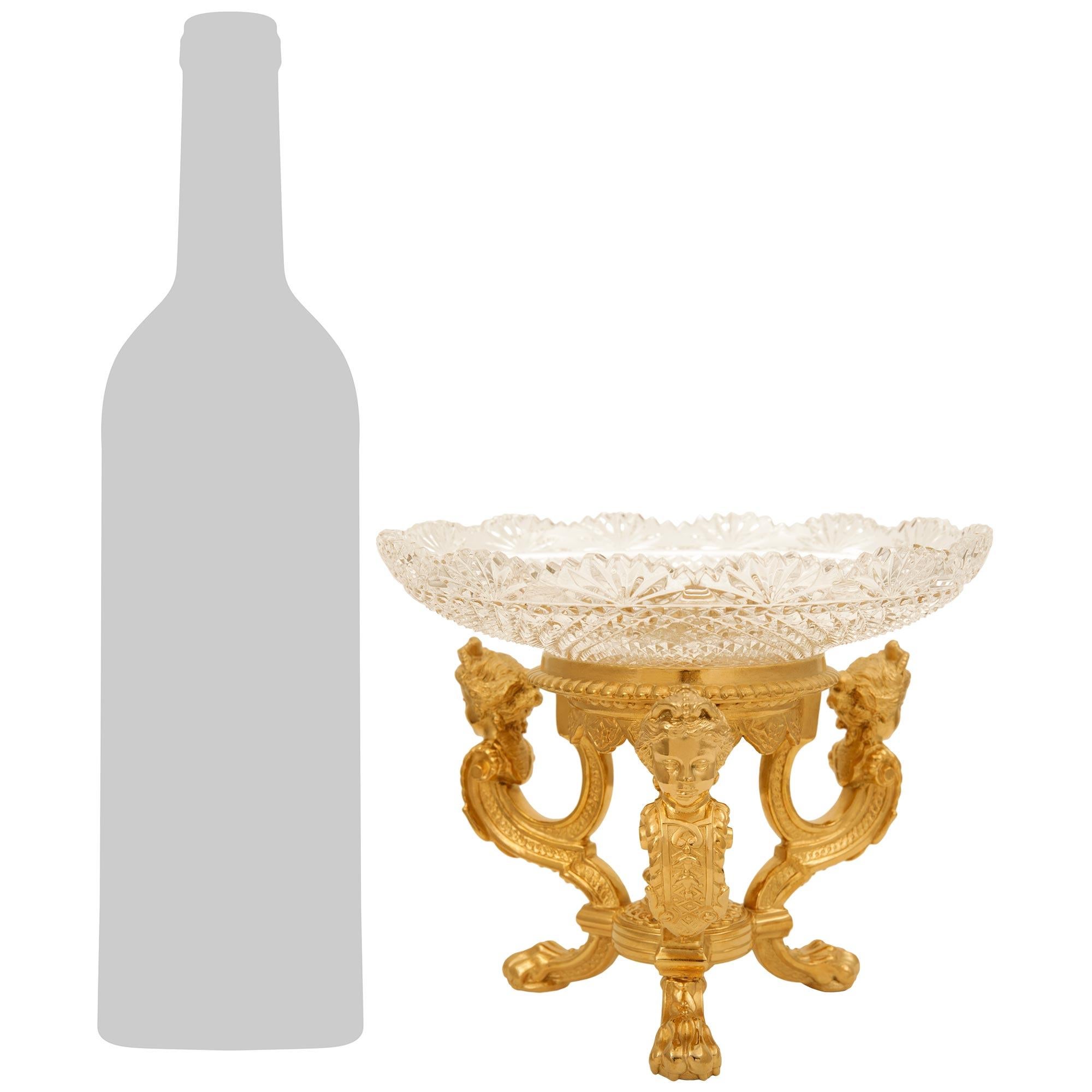 Un llamativo y elegantísimo centro de mesa americano del siglo XIX, de ormolu y cristal, de estilo Luis XVI. La pieza central se eleva sobre tres soportes bellamente ondulados con bonitas patas de garra y encantadoras bandas geométricas entrelazadas