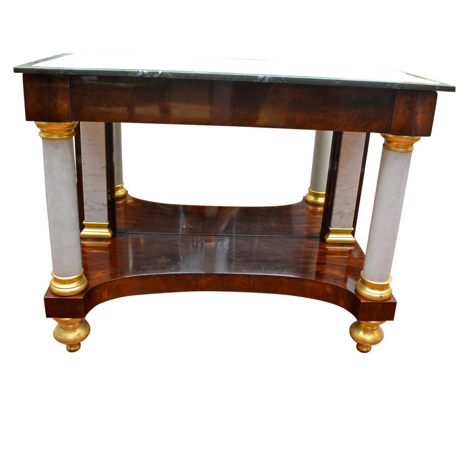 An American ‘Federal’ console with a mirrored back in well figured ‘crotch’ mahogany with white marble front columns and matching white marble pilasters to the rear, with gold leaf capitals, and feet. The white marble top with a light green band is