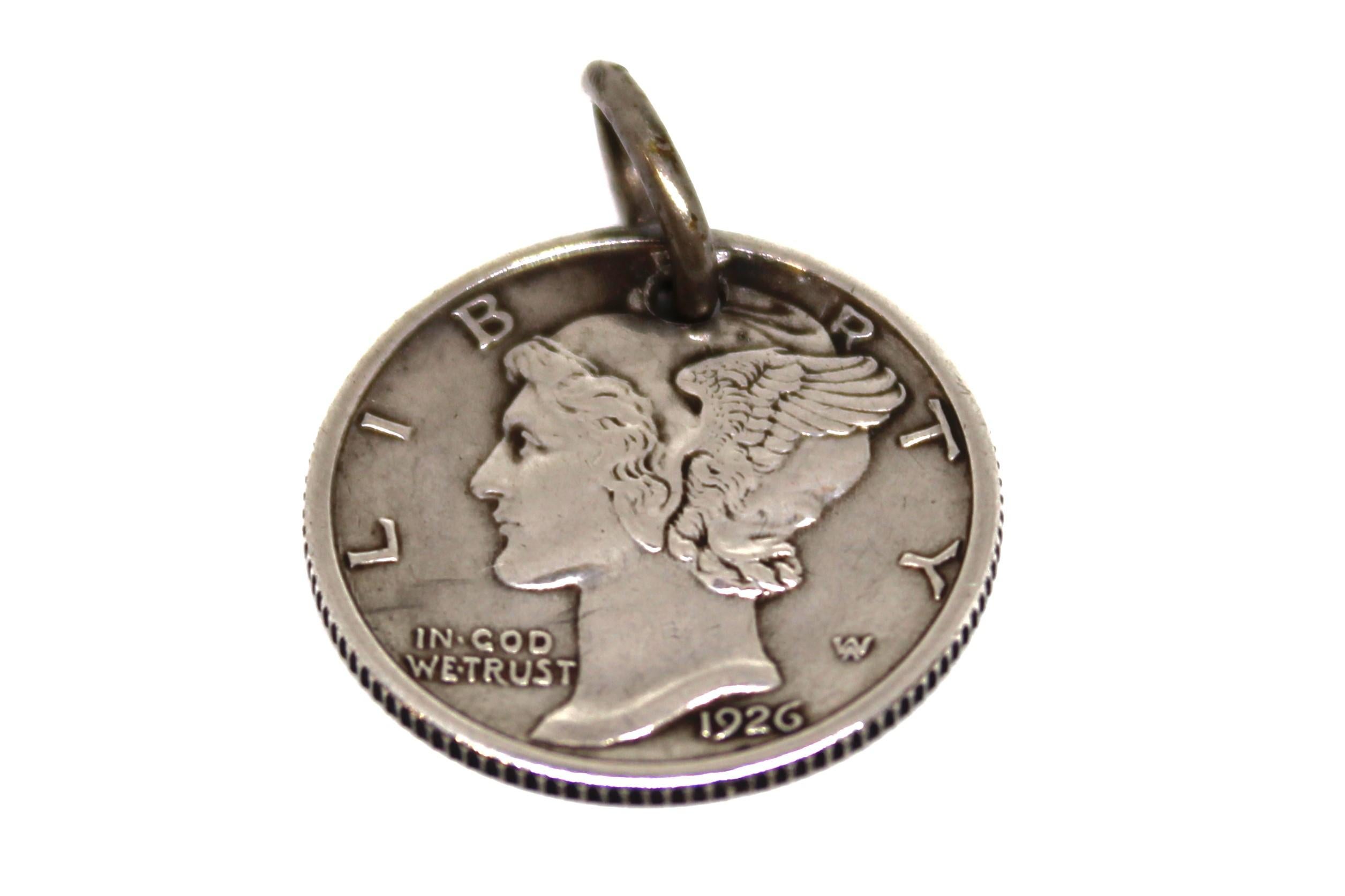 Cette amulette unique, fabriquée à partir d'une pièce de 10 cents Mercury de 1926, reflète à la fois la foi personnelle et la créativité de l'artisan. Le propriétaire d'origine a transformé cette pièce en polissant soigneusement le verso, créant