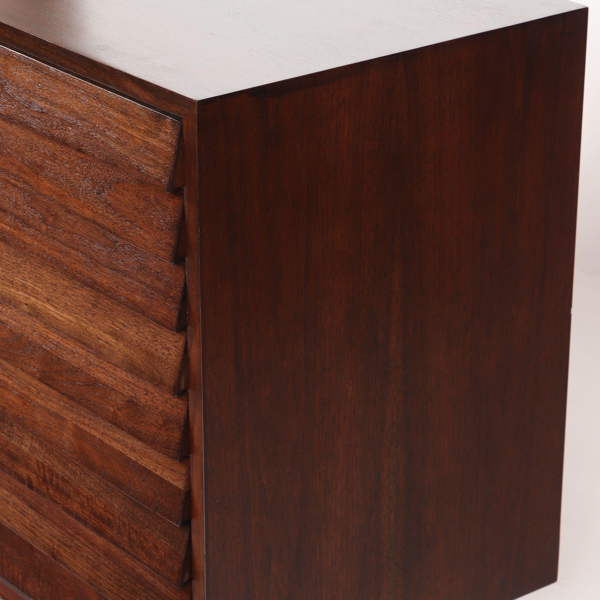 An American of Martinsville Merton Gershun Mid-Century Modern walnut dresser having three central drawers flanked on each side by three louvered drawers circa 1960.