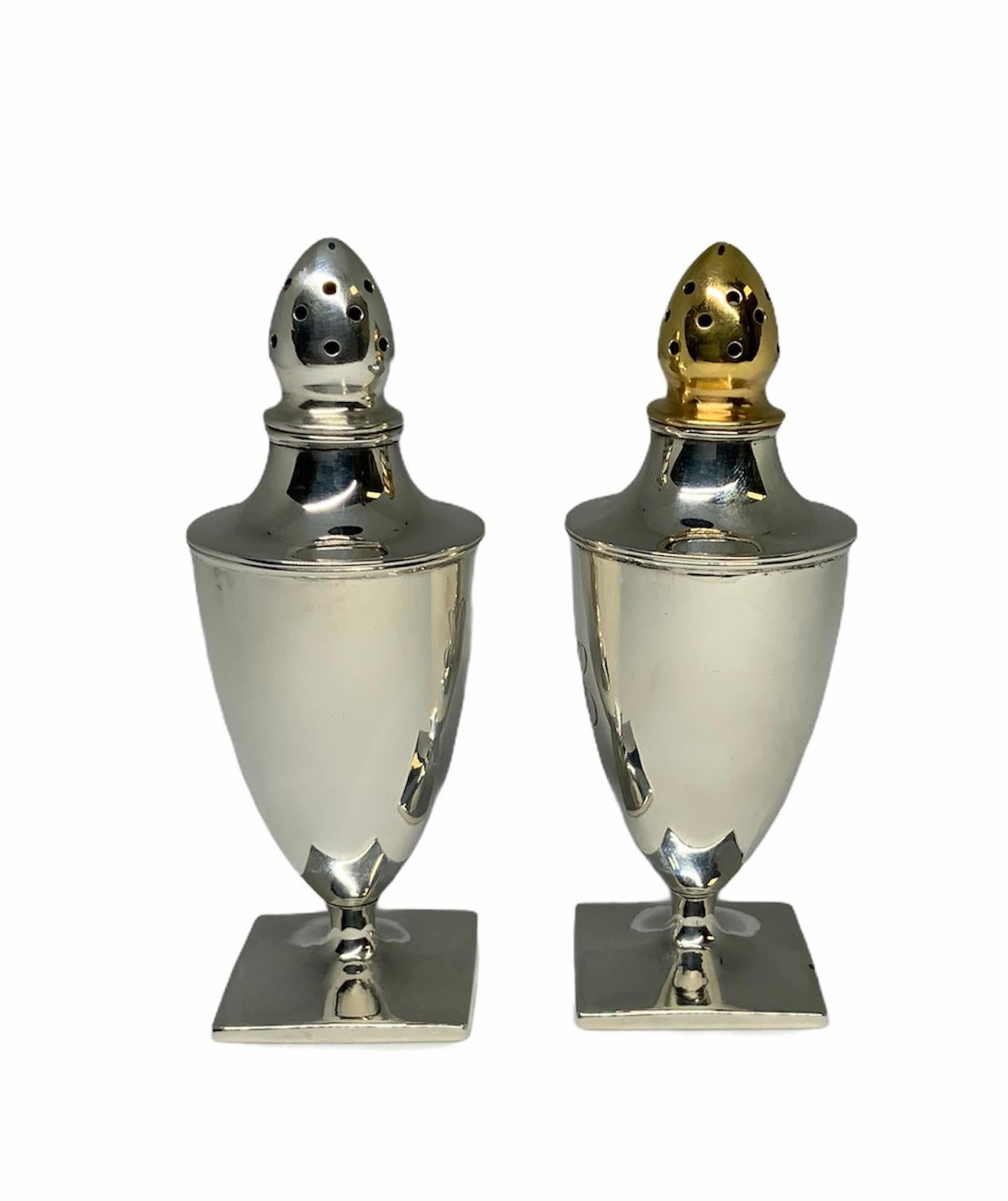 This is a set of possible Gorham sterling salt and pepper shakers. Both of them have a shiny smooth surfaces and have engraved in a beautiful calligraphy the letters: PBTS. They are urn shaped with square base and the tops are shaped as an upside