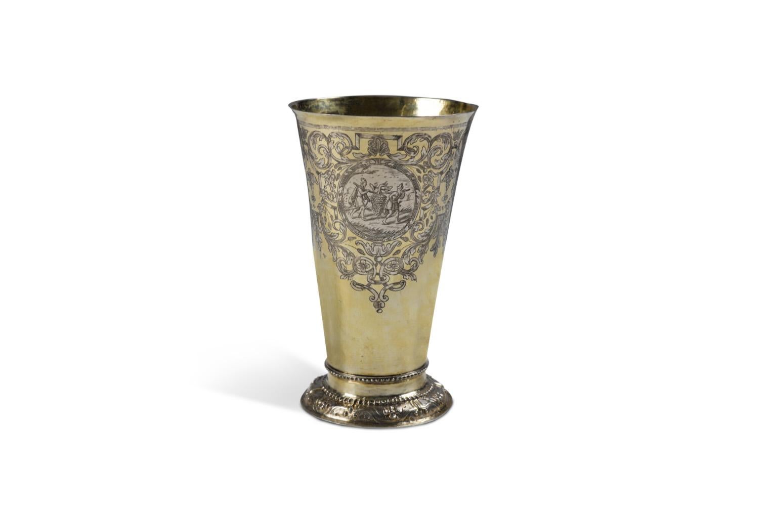 Questo eccezionale bicchiere d'argento dorato, realizzato dal maestro di Francoforte Samuel Birckenholtz intorno al 1710, è un ottimo esempio di argenteria tedesca del primo Settecento.

Di forma cilindrica e affusolata, il bicchiere poggia su un