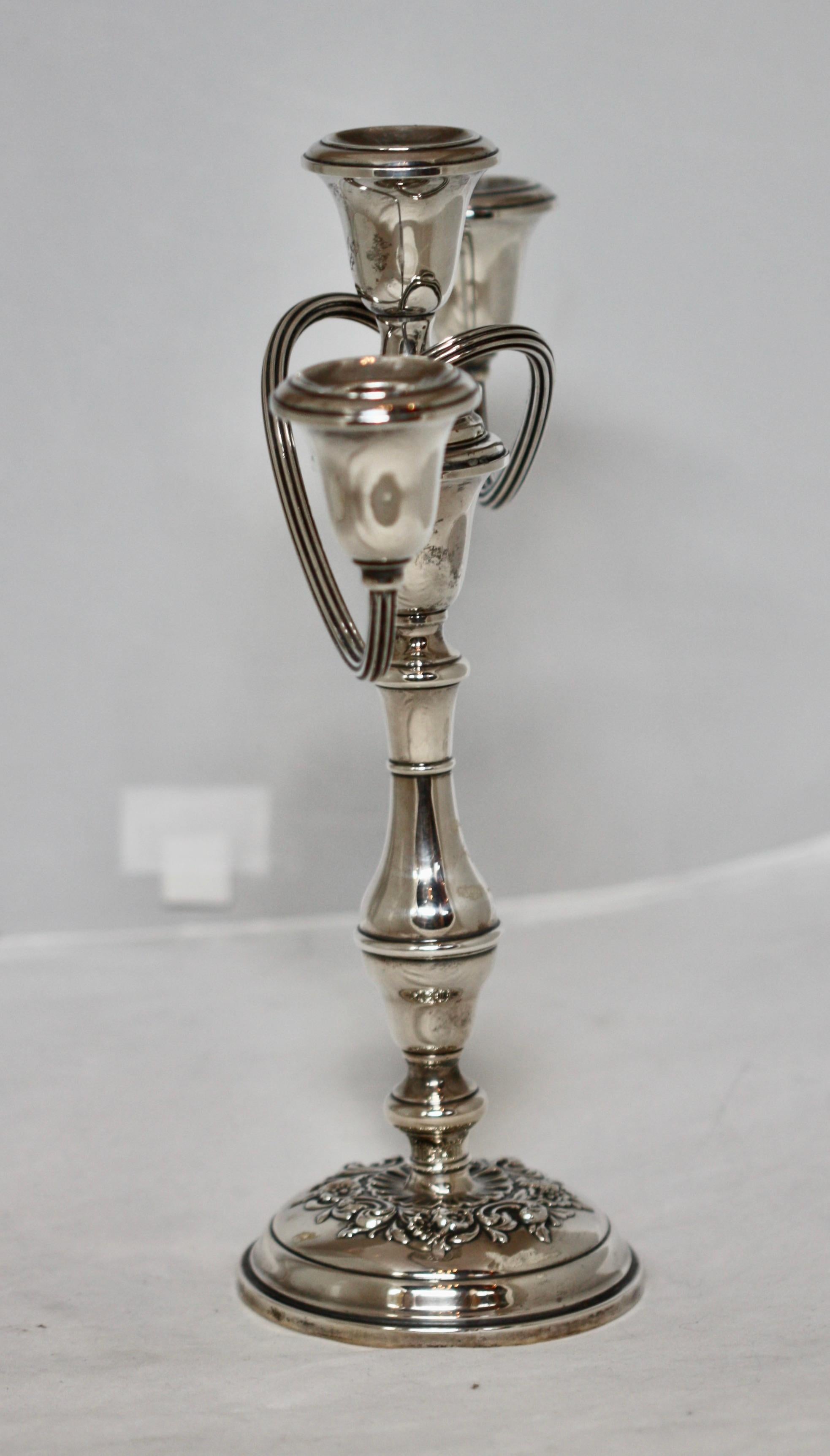 An American silver three-light candelabra

Gorham Mfg. Co., Providence, RI, on a circular lobed base chased with berried foliage rising to a baluster stem with three scrolling branches surmounted by fixed foliate drip pans and nozzles, marked on