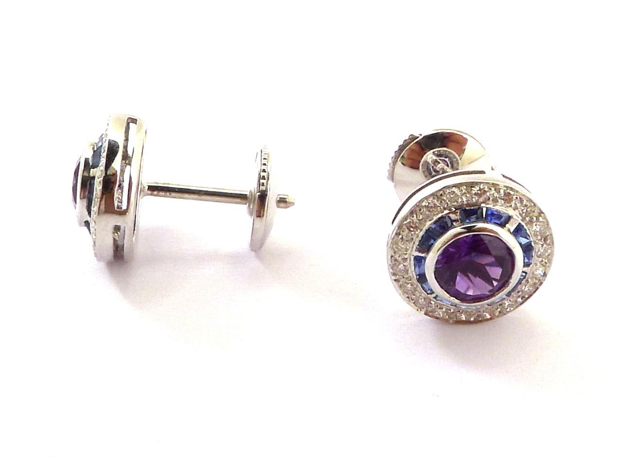 Centering a round brilliant cut amethyst surrounded by a fine line of baguette sapphires surrounded by round brilliant cut diamonds 

Mounted in 18k white gold

- Amethyst : 0.90cts
- Sapphire: 0.40cts
- Diamond: 0.18cts
- Gold: 3.35grs
- Total
