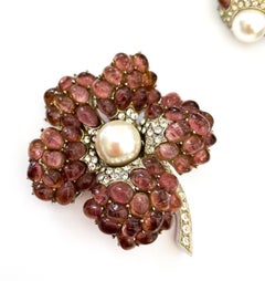 An amethyst glass cabuchon 'flower' brooch, and earrings, Marcel Boucher, 1960s.