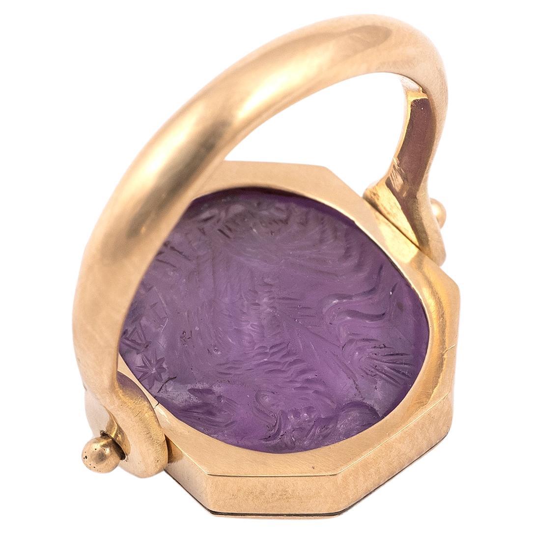 An amethyst double faced intaglio with a standing cockerel to the right with a palm frond behind and inscribed 'IAW' with a star. The reverse shows an ibis with an inscription above.   
The subject and inscription suggests that we are dealing with a