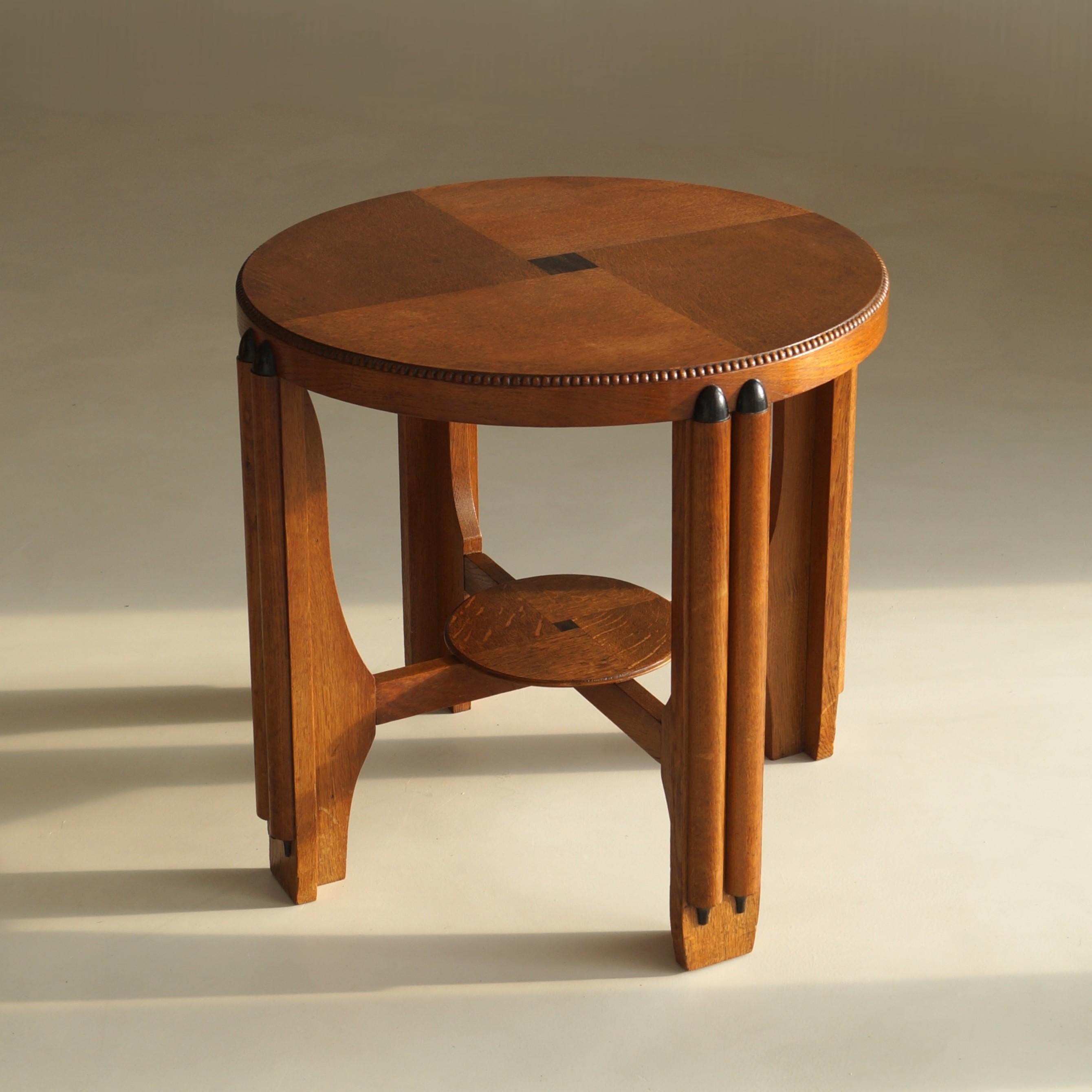 A beautifully composed 1920s Dutch Art Deco side table in oak, oak veneer and coromandel veneer. This piece is an elegant study in symmetry, contrast, and early twentieth-century craftsmanship. 

The sculptural base gives the table much of its