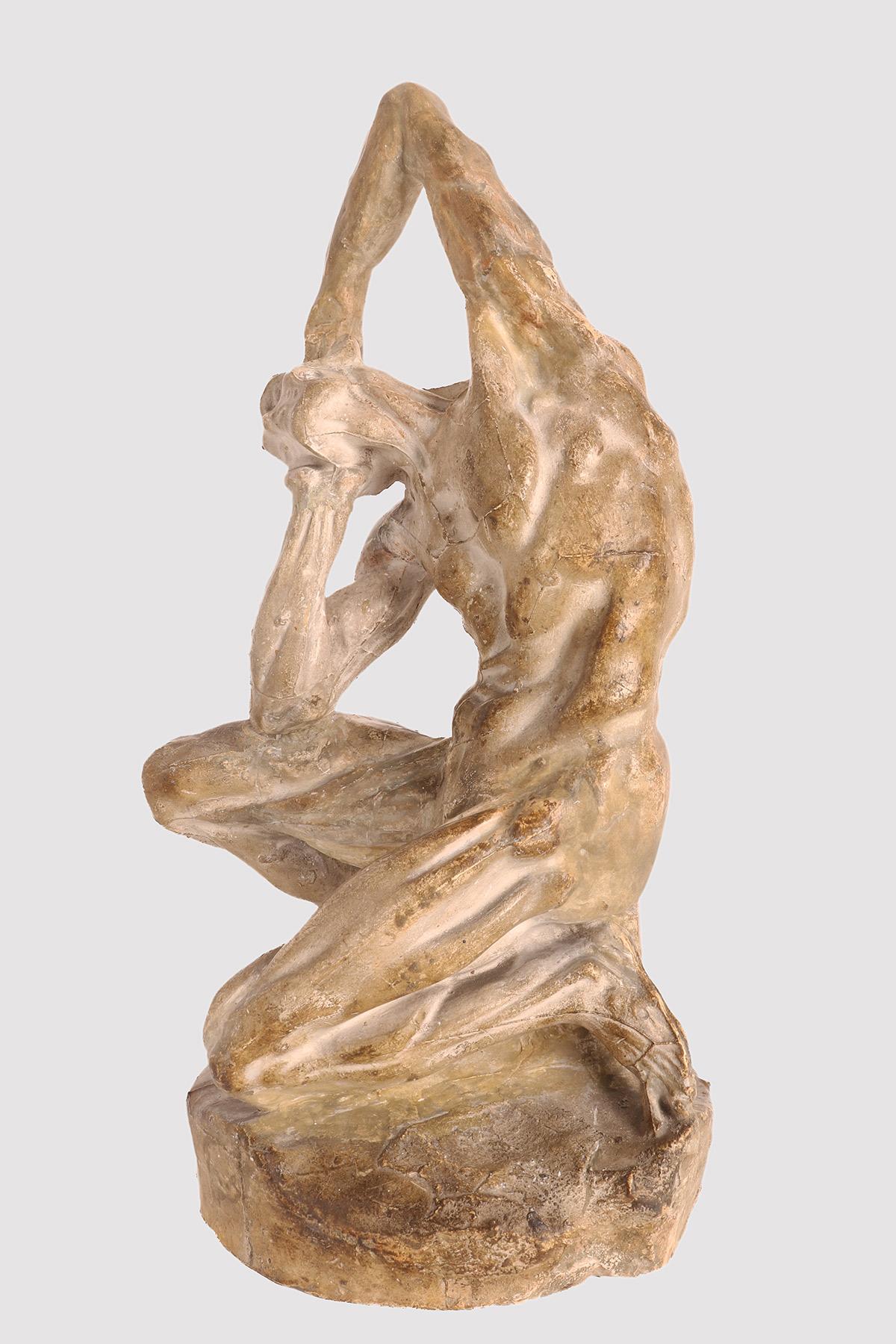 An anatomical plaster sculpture, depicting a flayed man seated on a cubic base, in a position with the torso tilted and the arms holding the head. Reference to a work of the French sculptor Pierre Puget (1620-1694). Anatomical study use. France