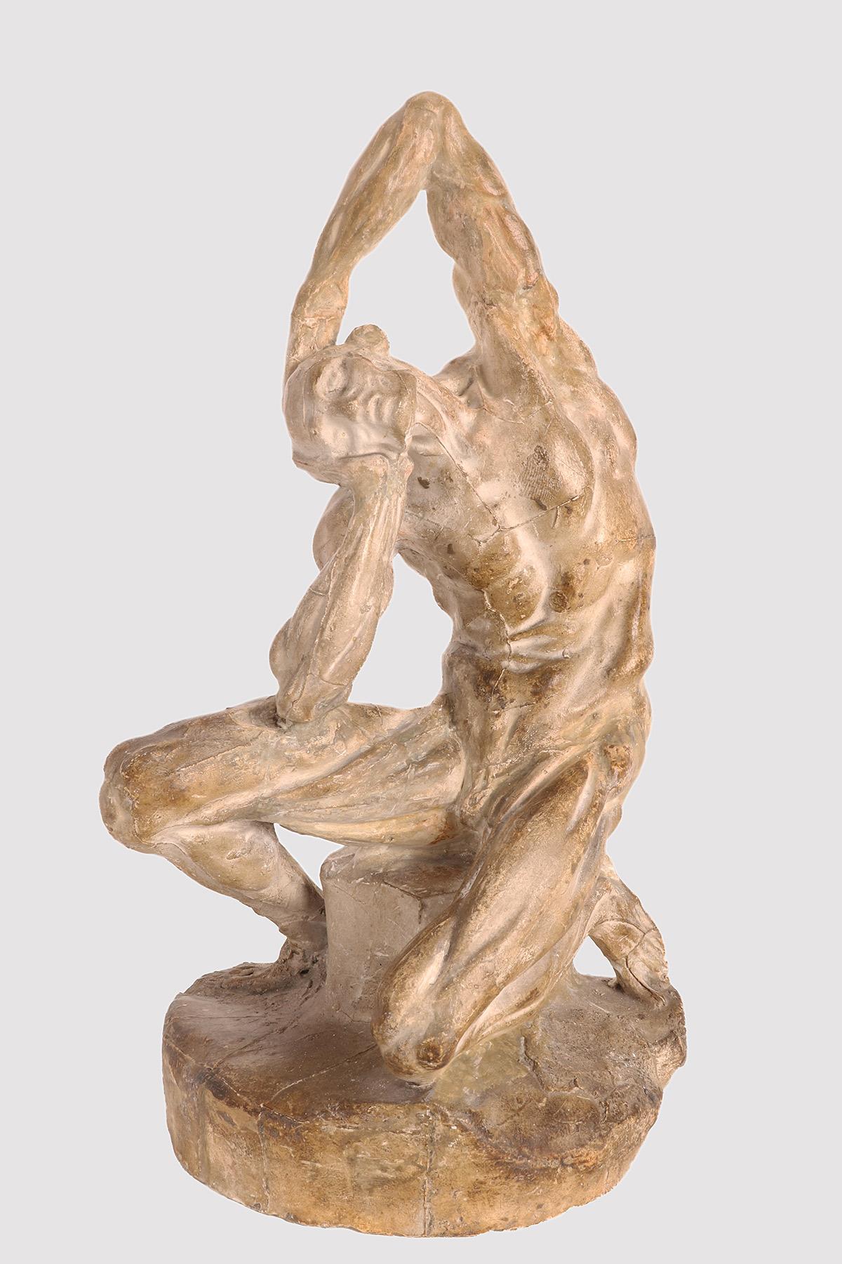 An anatomical plaster sculpture, depicting a flayed man seated on a cubic base, in a position with the torso tilted and the arms holding the head. Reference to a work of the French sculptor Pierre Puget (1620-1694). Anatomical study use. France