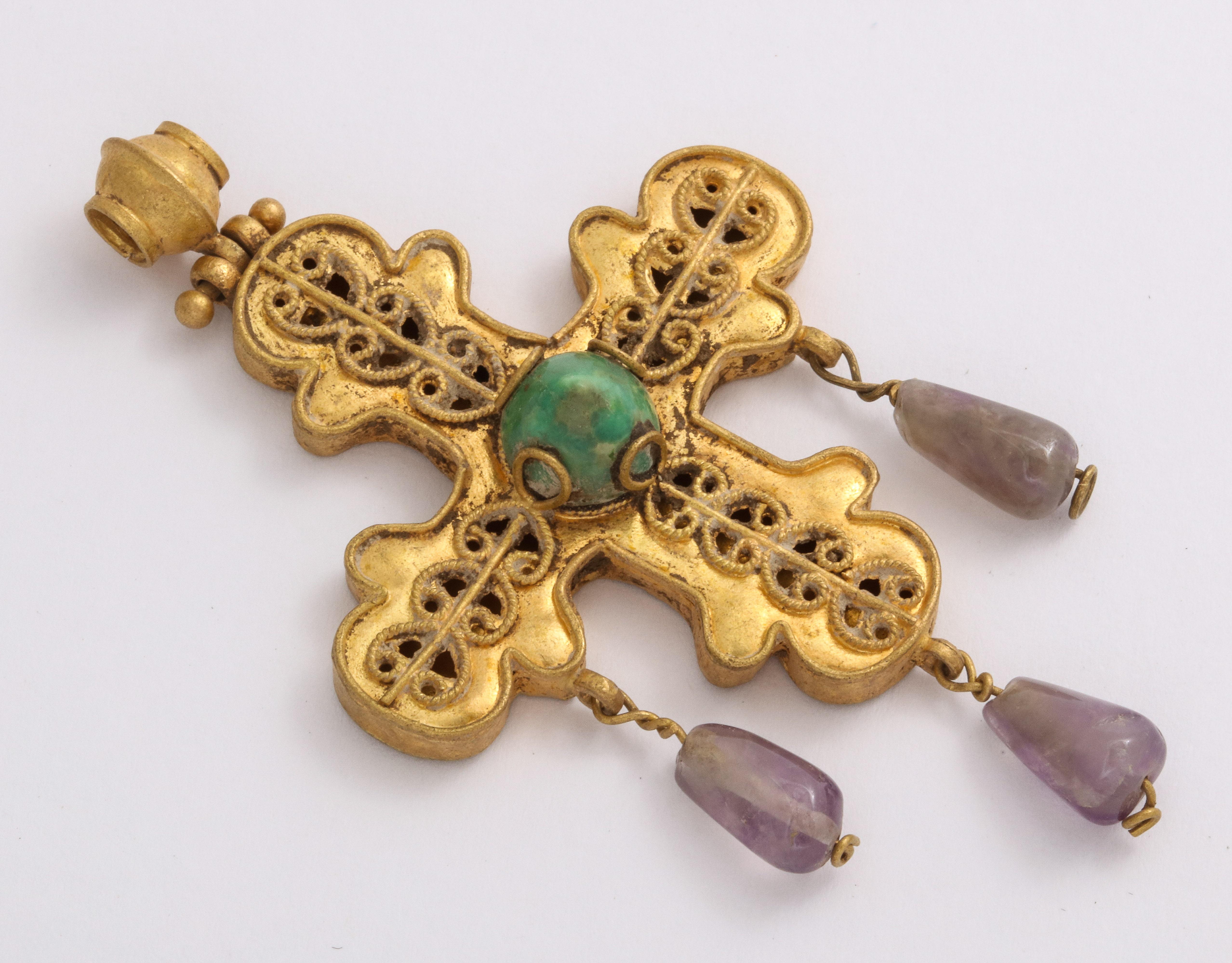 Made from the fine jewelers of the Byzantine period, known for their quality, this magnificent openwork cross suspends three teardrop amethyst stones and is centered with a conical emerald. Enlarge the images and take in the openwork that is