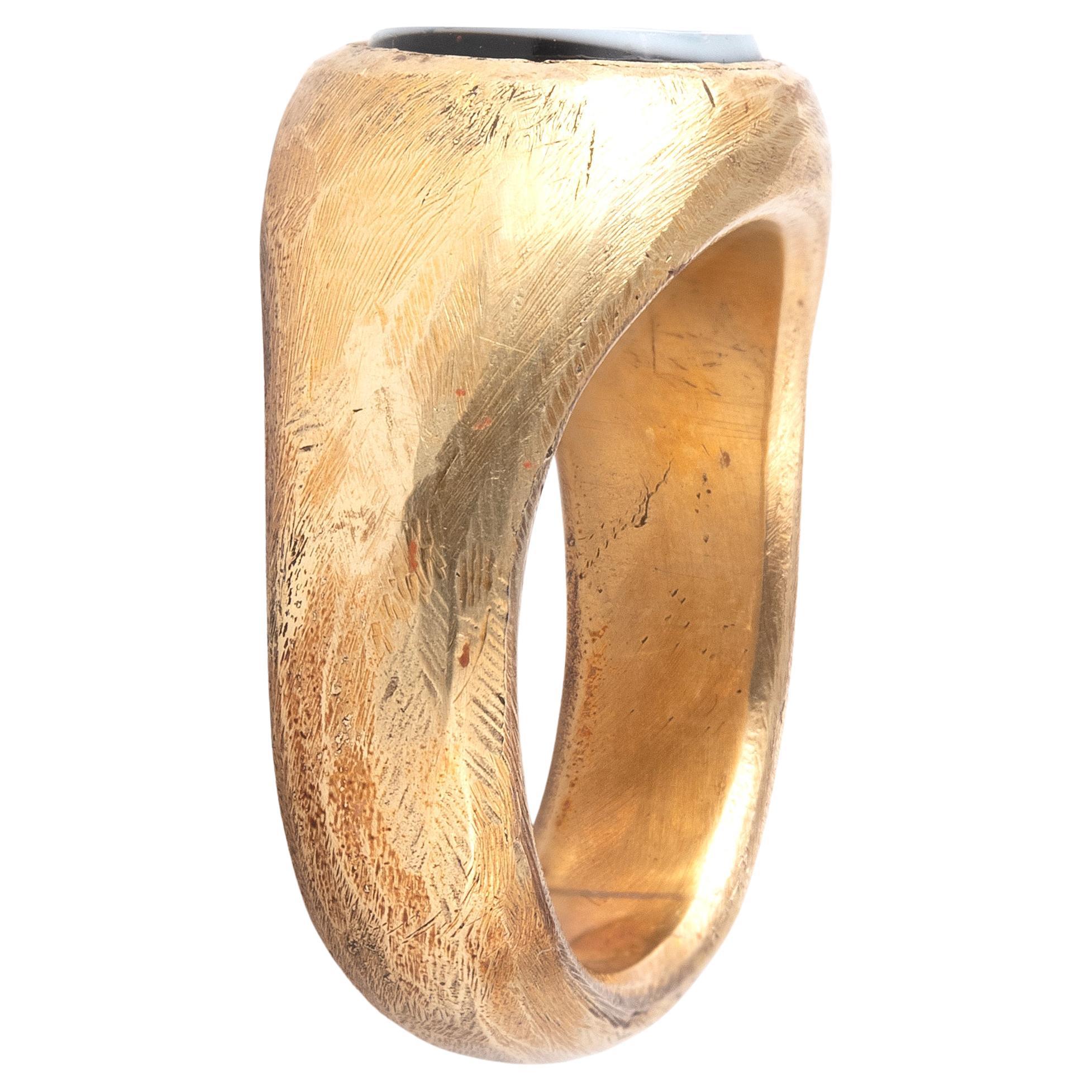 Une ancienne pierre romaine en intaille nicolo, datant des 1er et 2e siècles ADS, est montée dans une monture moderne en or à haute teneur en carbone.

La pierre est gravée de Janus, le dieu romain du changement, de la transition et de tous les