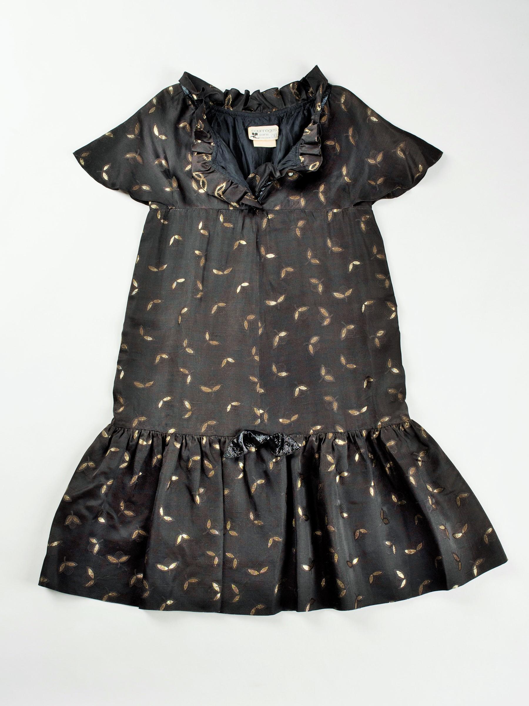 Vers 1965-1970. France
Rare modèle de robe Baby Doll d'André Courrèges Haute Couture modèle 23075 et datant de la fin des années 1960.  Robe courte sans manches, forme trapèze, taille haute avec un large volant plissé sur les hanches. Acétate de