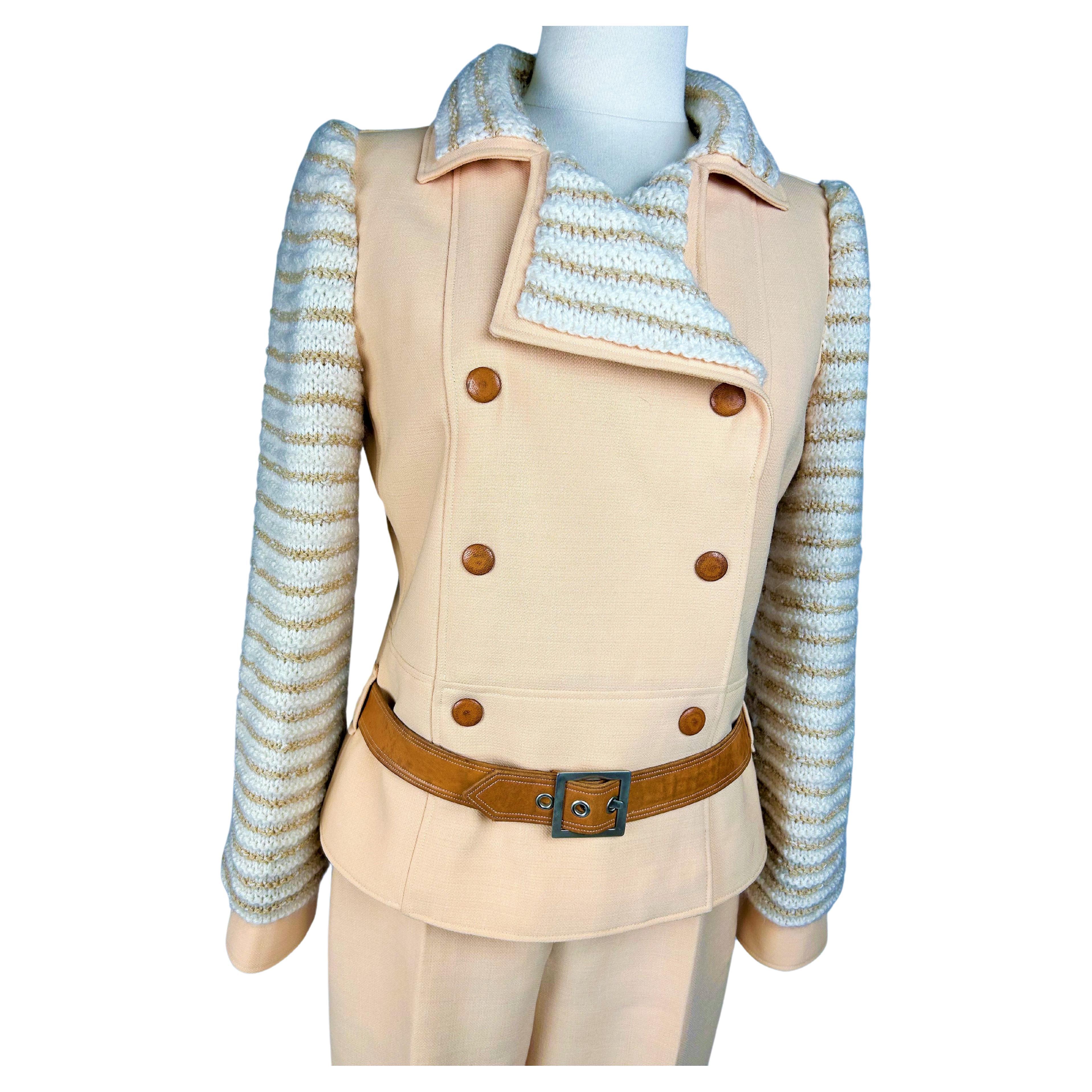 Circa 1975

France

Cream brushed jersey trouser suit by André Courrèges Couture Future numbered 046282 and 045768 and dating from the 1970s. Fitted jacket with crossed panels and six press studs sheathed in fawn-coloured leather with cuffs. Collar