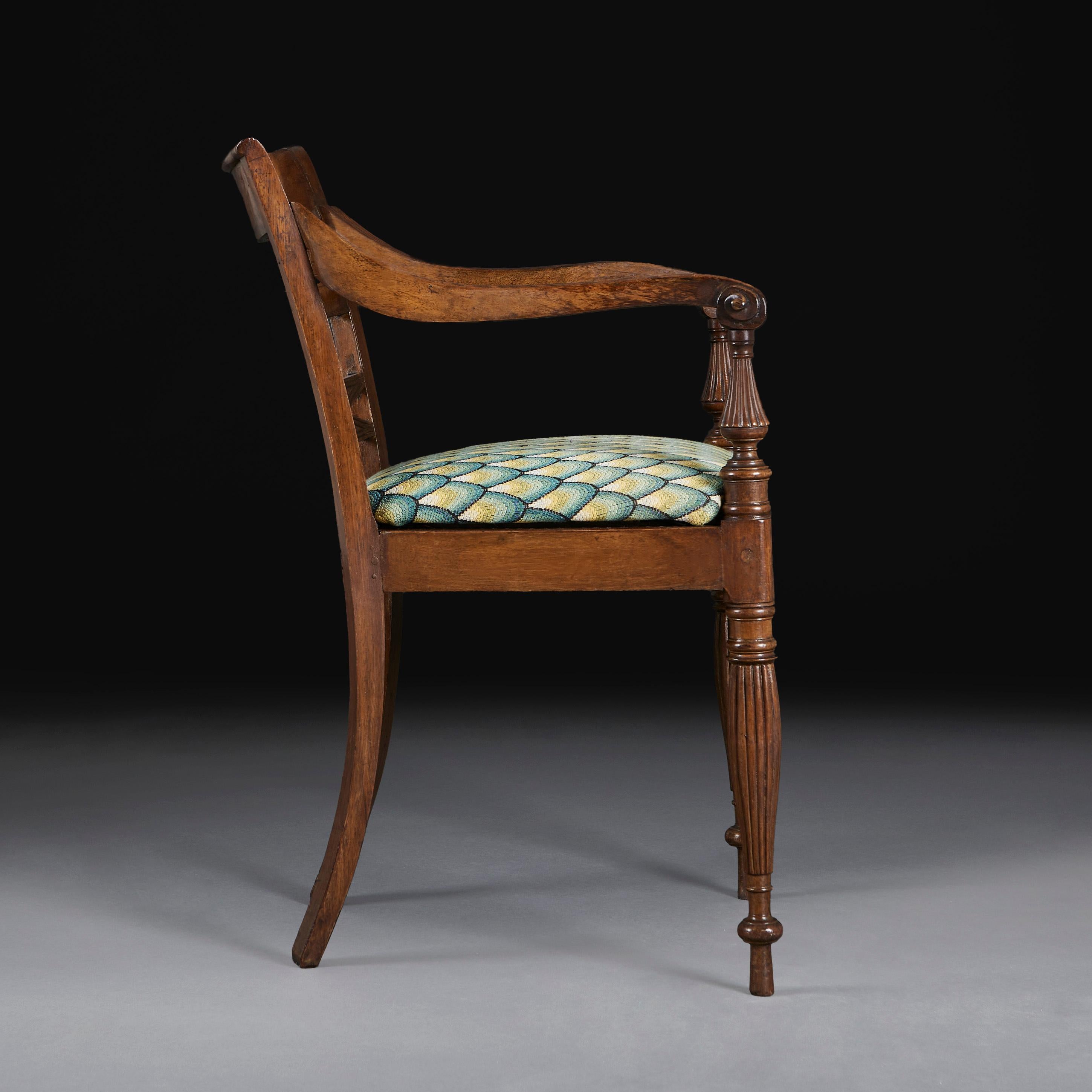 Chaise de bureau anglo-indienne du milieu du XIXe siècle, avec des accoudoirs ouverts se terminant par des volutes, les pieds avant étant sculptés de godrons sur toute leur longueur. Le siège est tapissé d'un décor à l'aiguille en écailles de