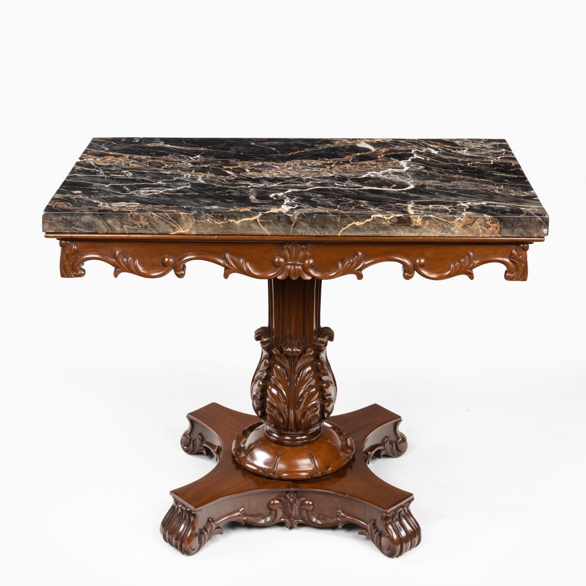 Table en acajou d'origine anglo-indienne avec plateau en marbre Nero portoro par White and Co Calcutta, le plateau rectangulaire en marbre reposant sur une frise sculptée de rinceaux feuillus, le support de colonne en roseau émergeant de quatre
