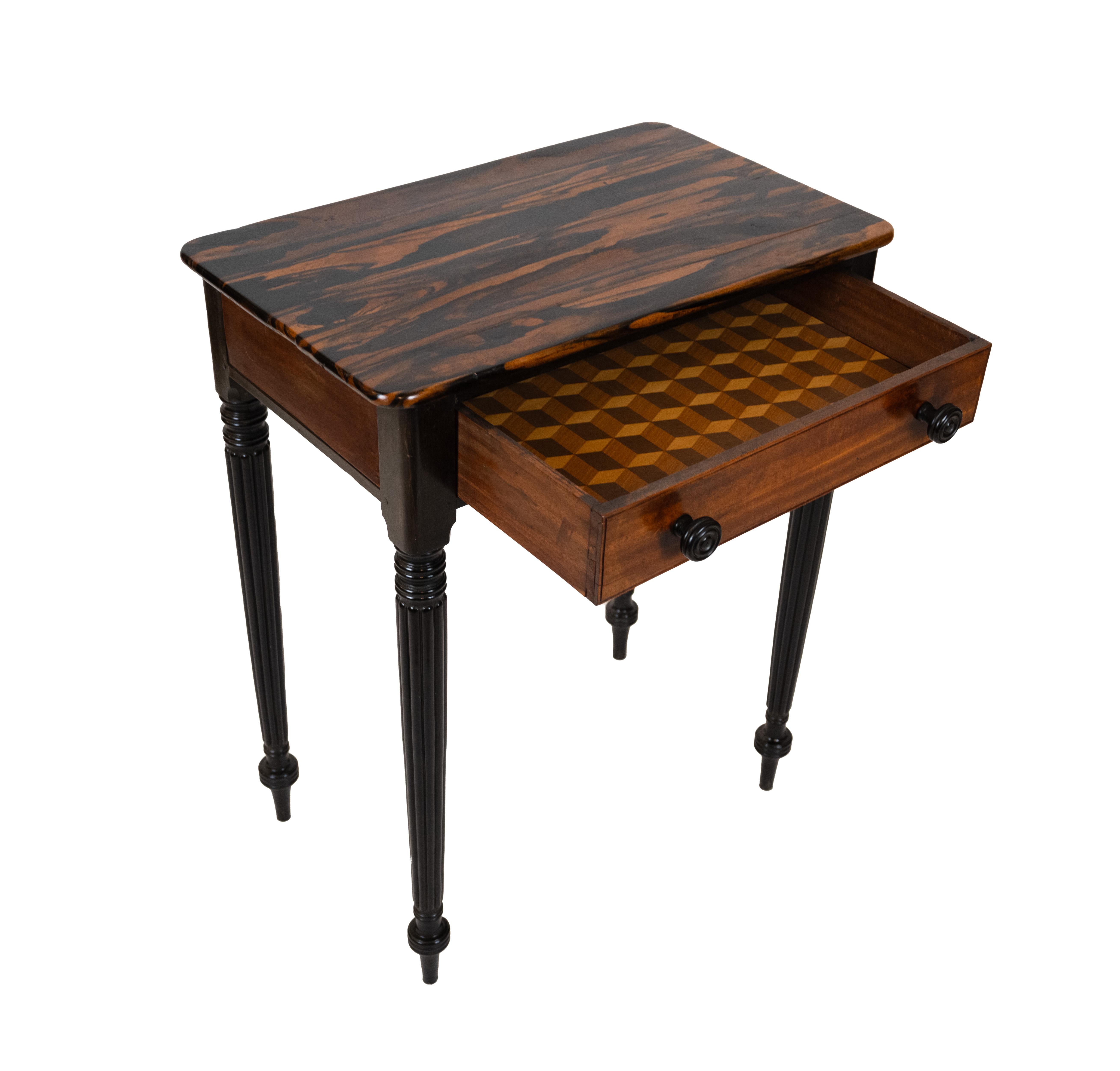 Table d'appoint anglo-indienne avec plateau en bois de rose hautement figuré. Le tiroir unique avec incrustation géométrique à l'intérieur, à l'intérieur d'un corps ébonisé soutenu par des pieds ébonisés cannelés et effilés. Circa 1880.