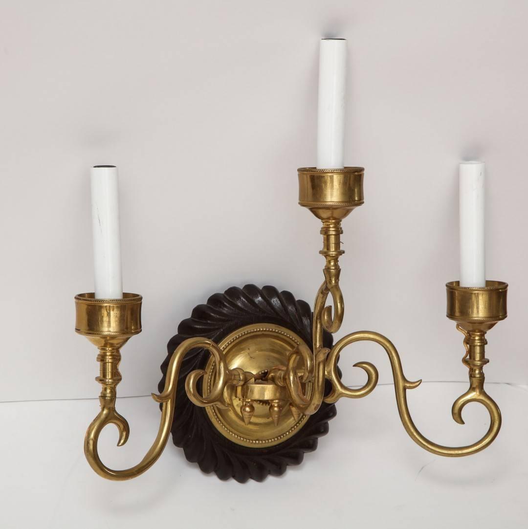 An Anglo-Indian three-light sconce, ebonized shell-form backplate issue three-light brass aperture, electrified.