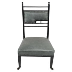 An Anglo-Japanese ebonized side or nursing chair with green hide upholstery