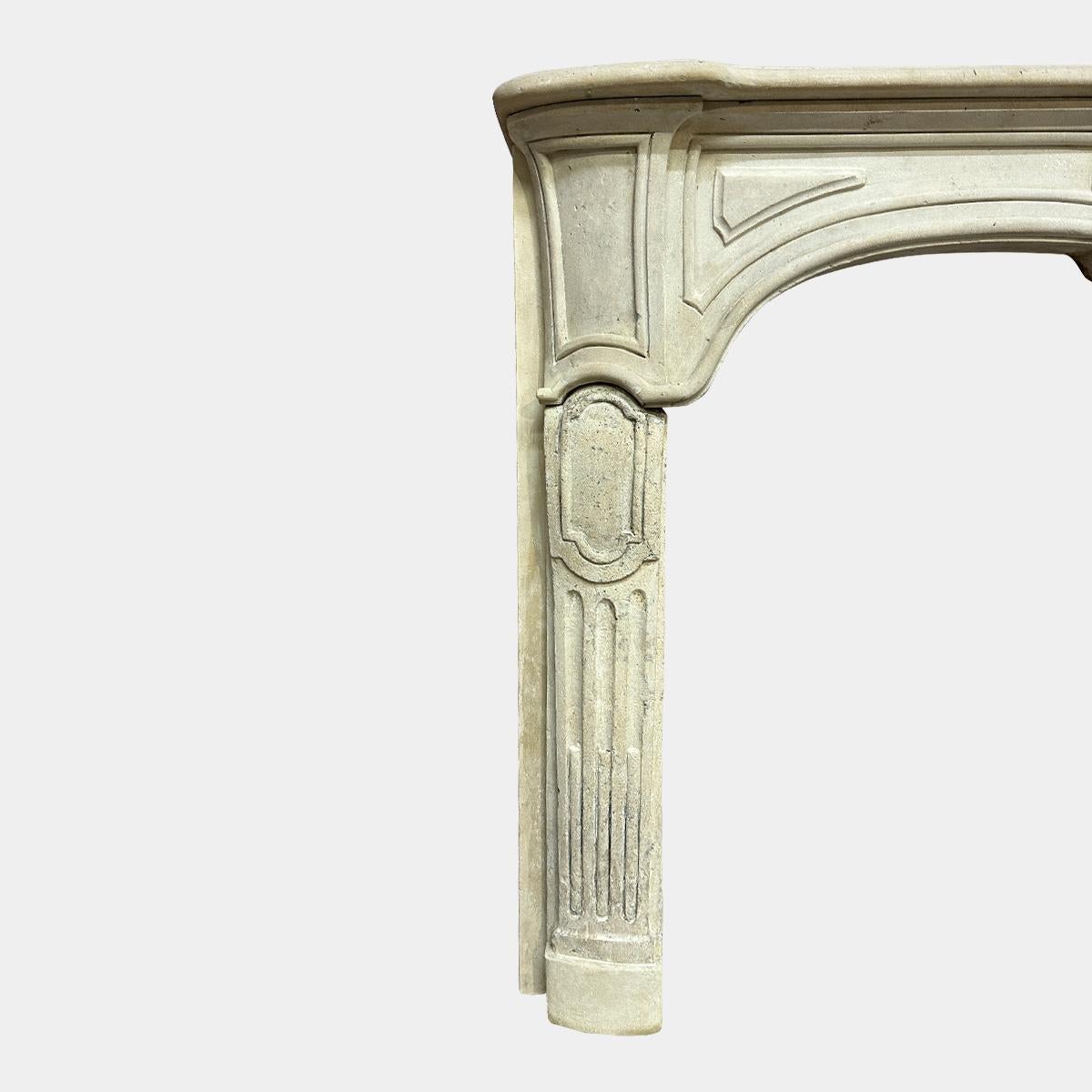 An 18th century French Caen Stone Provincial Fireplace. The cantered jambs with stop fluted front panels and carved raised panels. The frieze serpentine in design with raised panelled end, raised fielded panels and carved centre cartouche. A wide