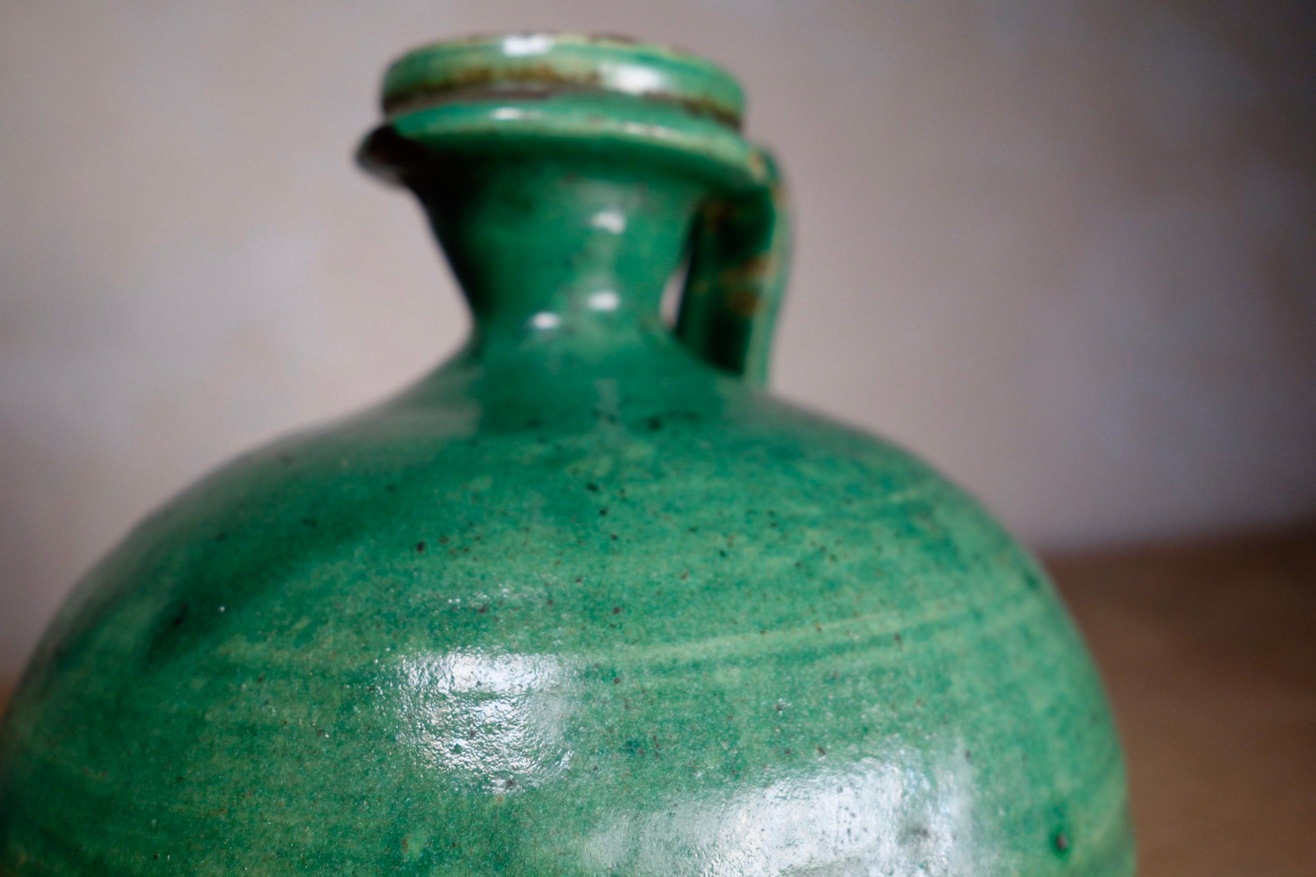 An antique French olive oil jug of small proportions, featuring a rich and deep almost two-tone green glaze. Demonstrating a small elegantly shaped handle with a sprouted neck, a very dainty and charming decorative piece.
Measures: Height 17 cm.