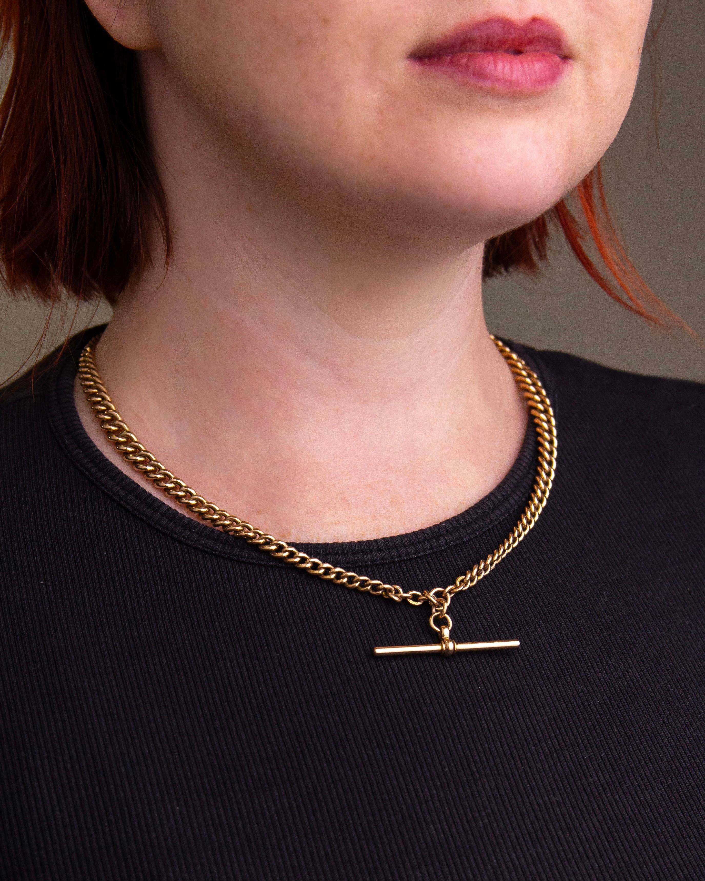 This 9 karat yellow gold fob chain was crafted in England in the first quarter of the 20th century. The curb link chain is graduated to both sides and terminates to the centre front with an attached 'T Bar'. Nearly every link of this fob chain is