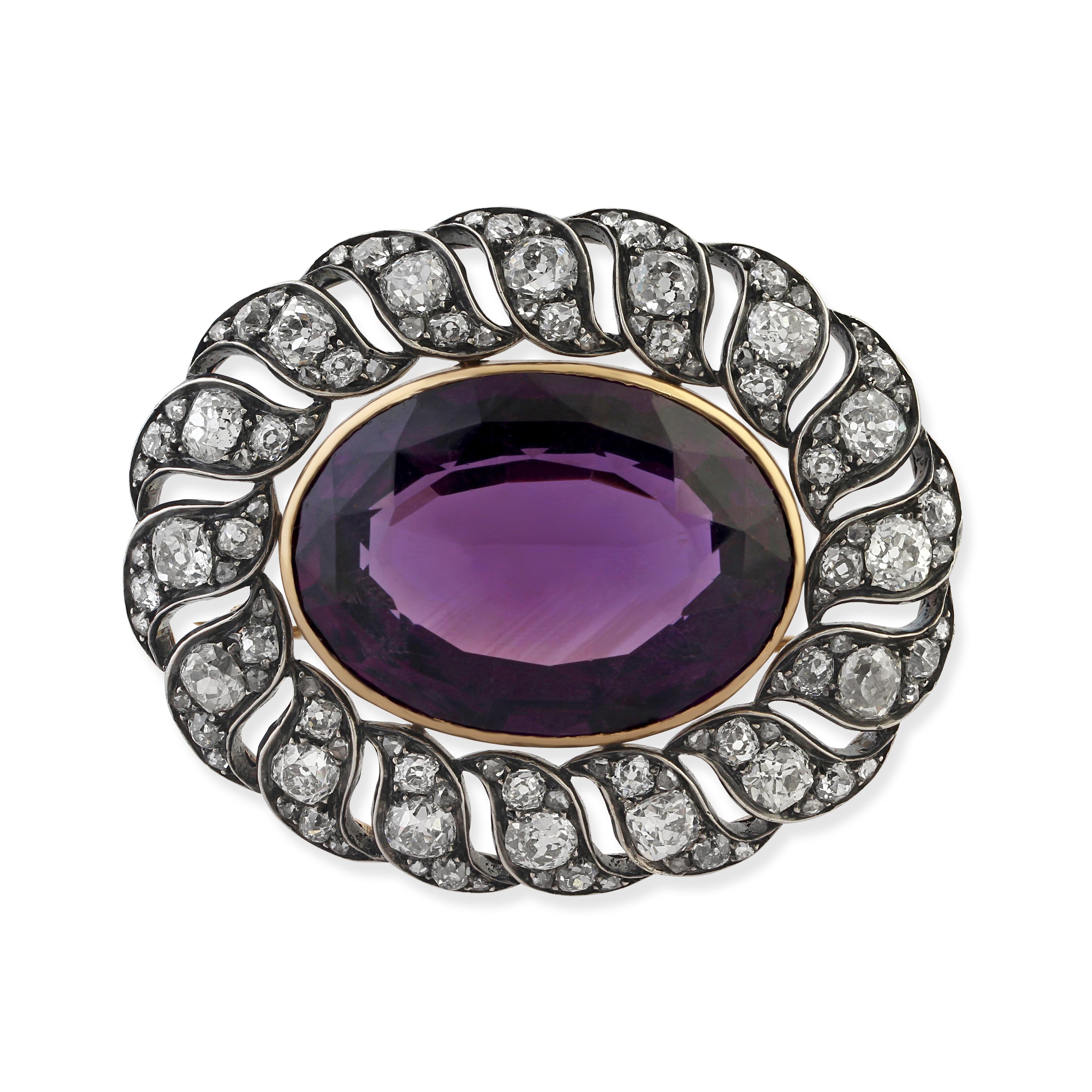 An antique silver on gold, amethyst and diamond brooch. Set with an oval cut amethyst in an openwork mount of old cushion-cut diamonds. Total diamond weight = apx 5.25cts. Circa 1850s.