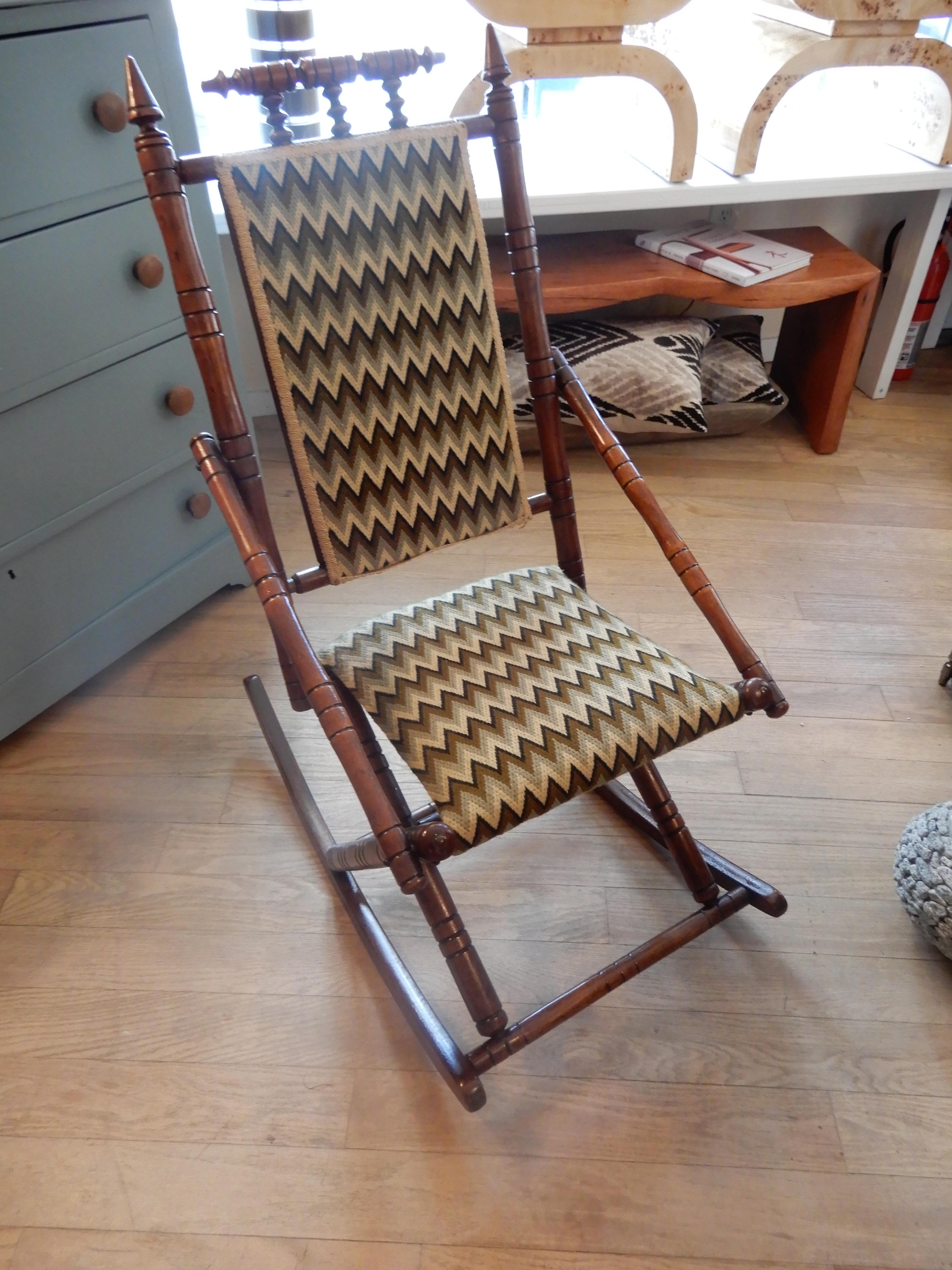 A charming little rocker with all the bells and whistles of the George Hunzinger style. Handcrafted and upholstered in a modern woven beige and green top grade fabric. Excellent condition.
