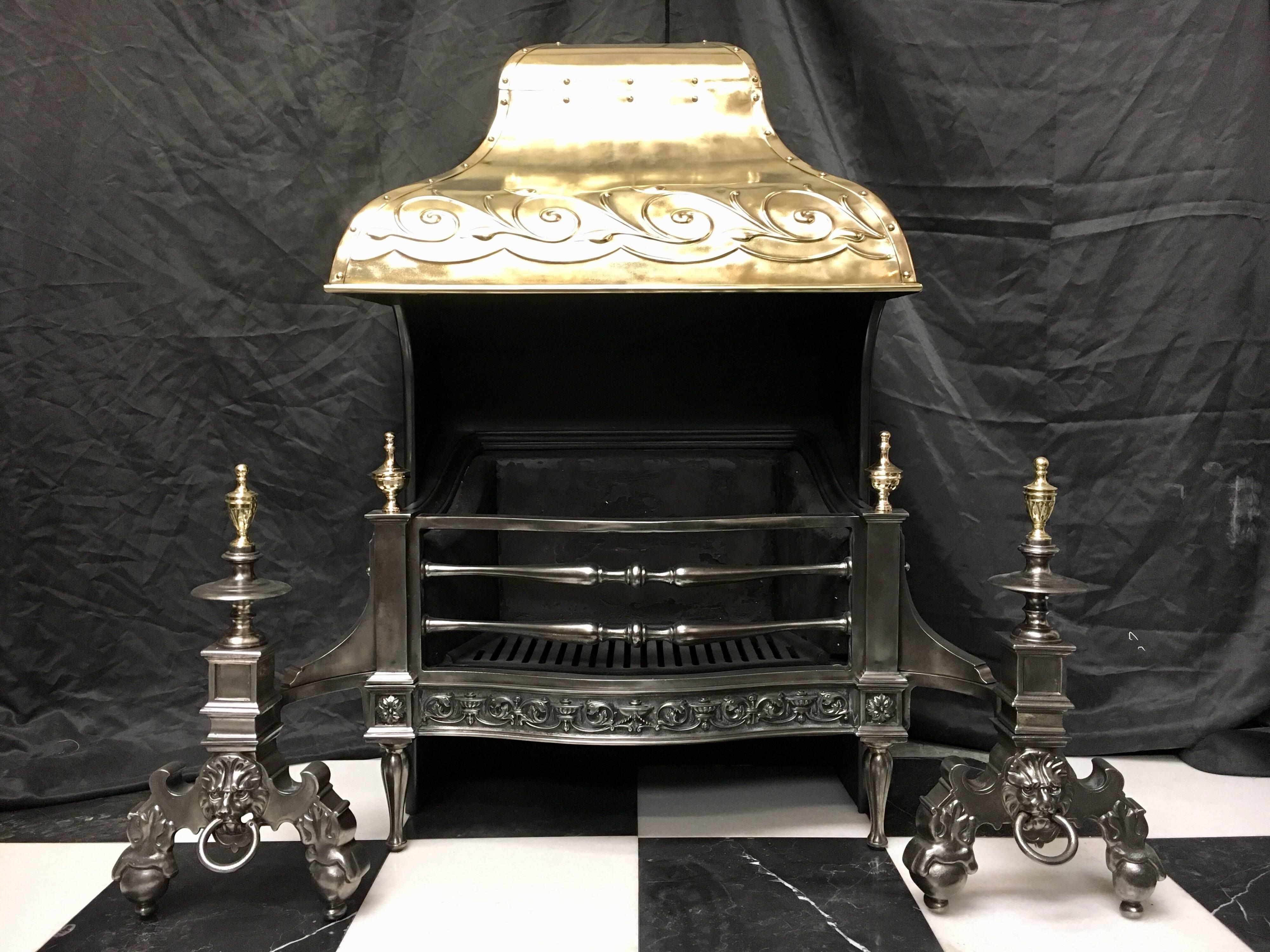 A handsome and substantial, late 19th century antique cast iron Baroque style hooded Victorian fire grate with a brass riveted and repousse hood. A three barred serpentine grate flanked by standards topped by brass finials, flanked by integral