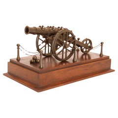 An antique bronze scale model of an 18th century cannon on a hardwood base c1920