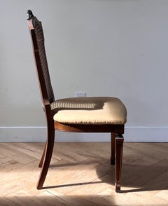 An antique carved wood and cane dining chair, turn of the century