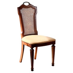 An antique carved wood and cane dining chair, turn of the century