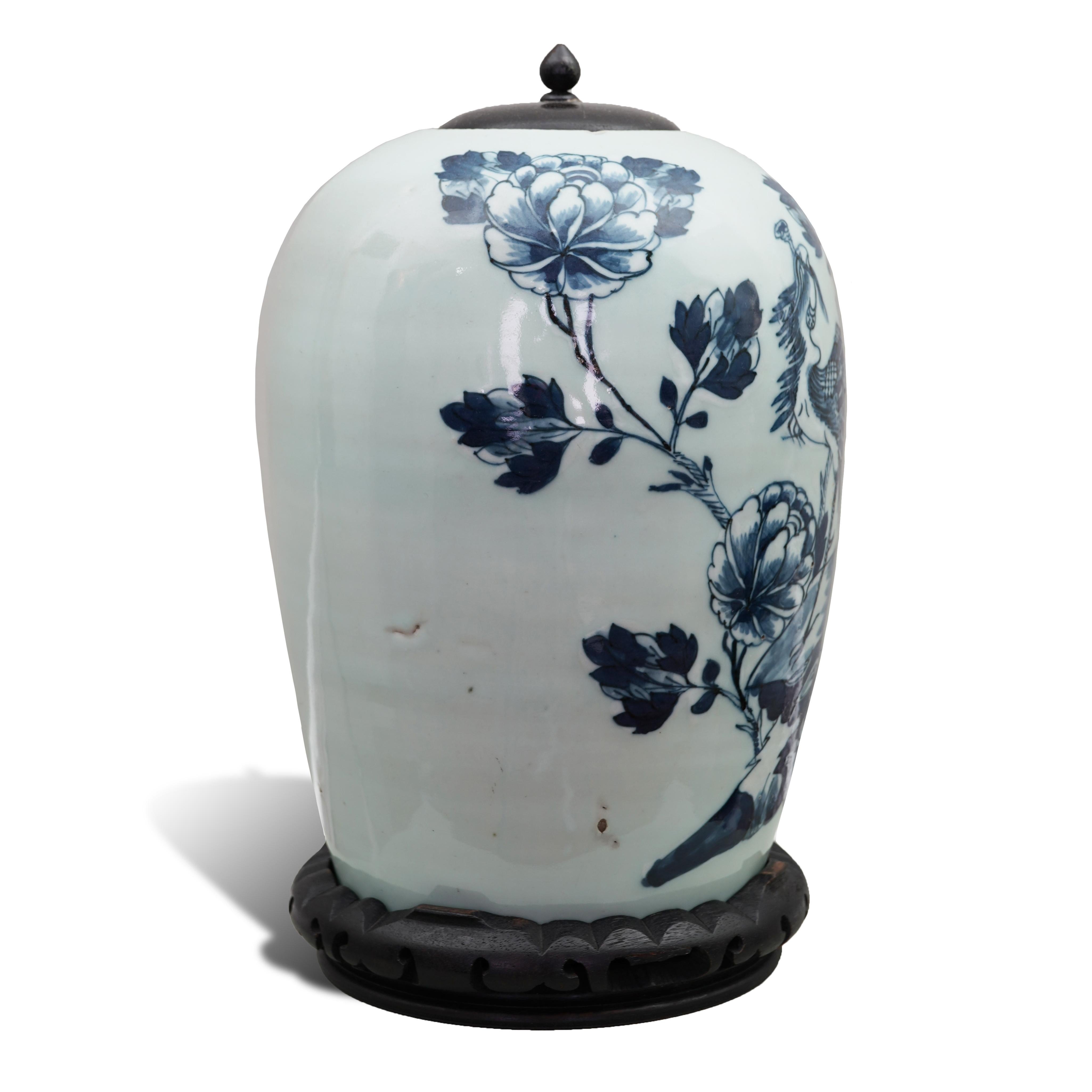A Celadon and Blue Porcelain ‘Phoenix’ Vase or Ginger Jar
China, Qing Dynasty, 19th century
With ebonised carved stand and lid
28 cm. / 11 ins high (overall 33 cm. / 13 ins), 20 cm. diameter

This lovely antique Chinese vase, possibly used as a