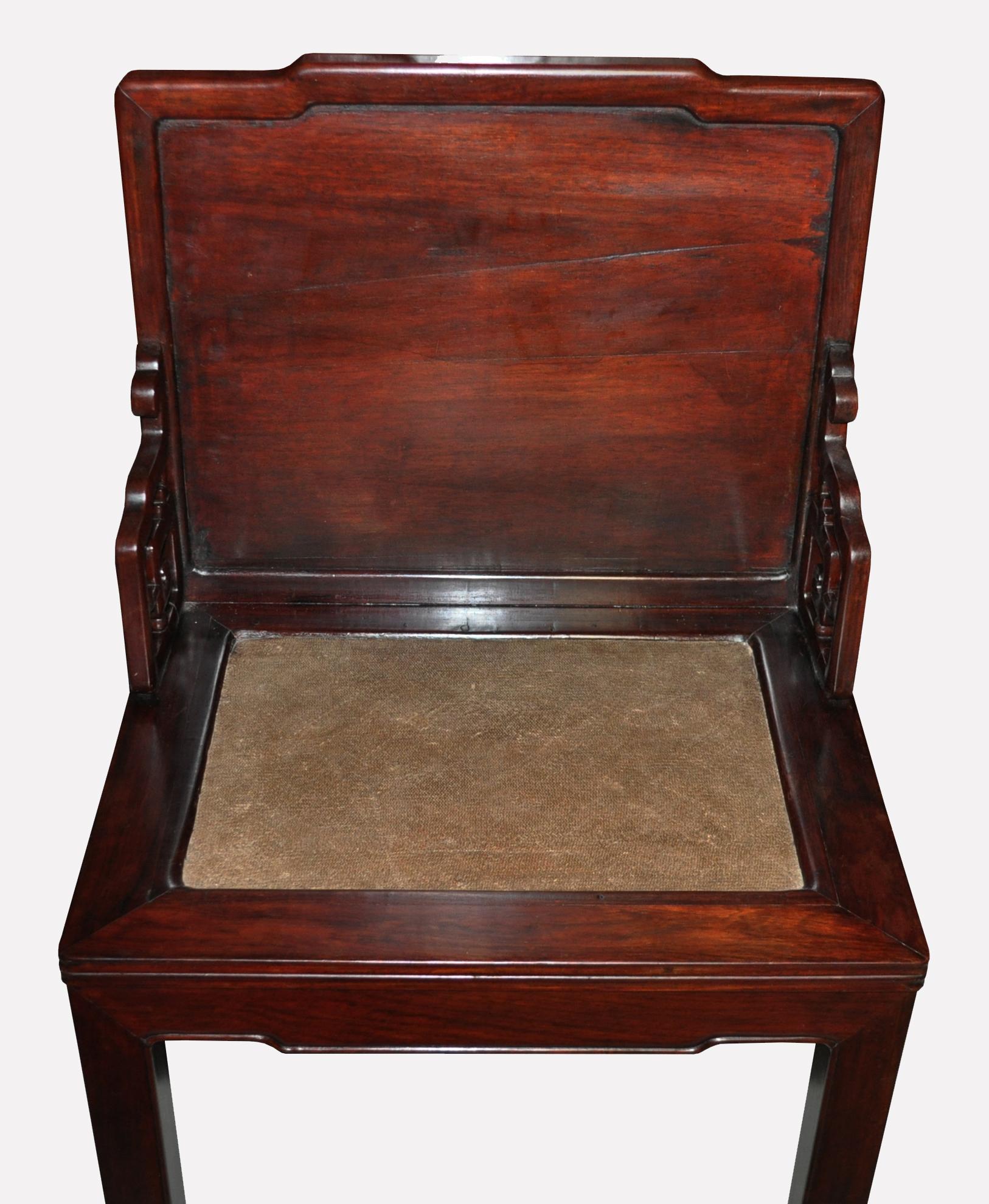 An antique Chinese hongmu (rosewood) side chair with raffia seat panel set within four frame members. The backrest is inserted into the seat frame and further secured by guazhi openwork corner spandrels. The legs are secured by shoulder joints to