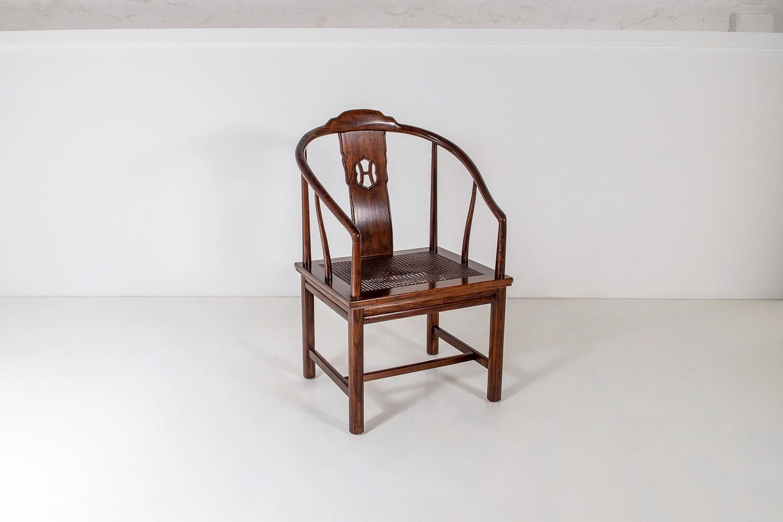 An early 20th century Chinese Horseshoe Chair of late Qing / early Republic Era. Superb form with horseshoe back and sweeping arms, single vertical slat carved backrest with roundel, a cane rectangular seat above a shaped apron and four round shaped