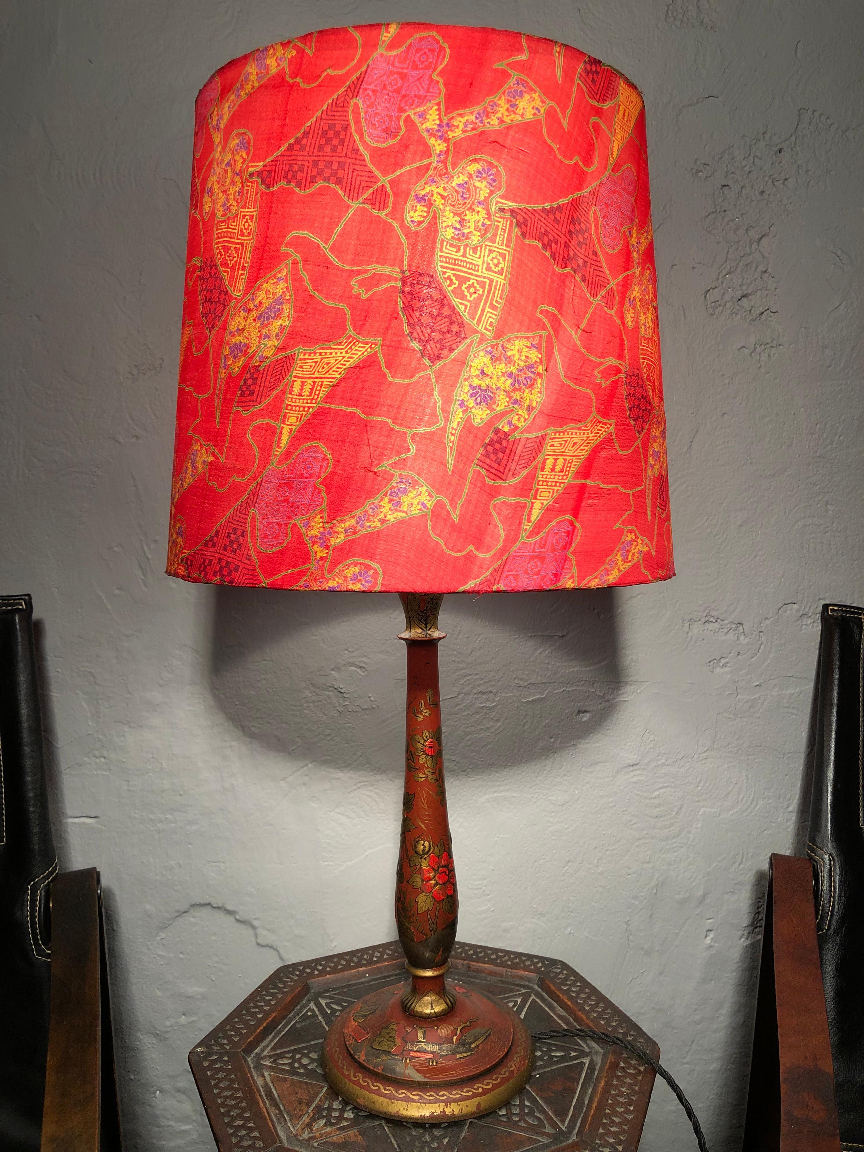 An antique Chinoiserie table lamp in a classic period design. 
Richly decorated base with butterflies, birds, flowers and architecture. 
Turned stem decorated with flowers.
Still maintaining the original brass and porcelain lamp holder with a